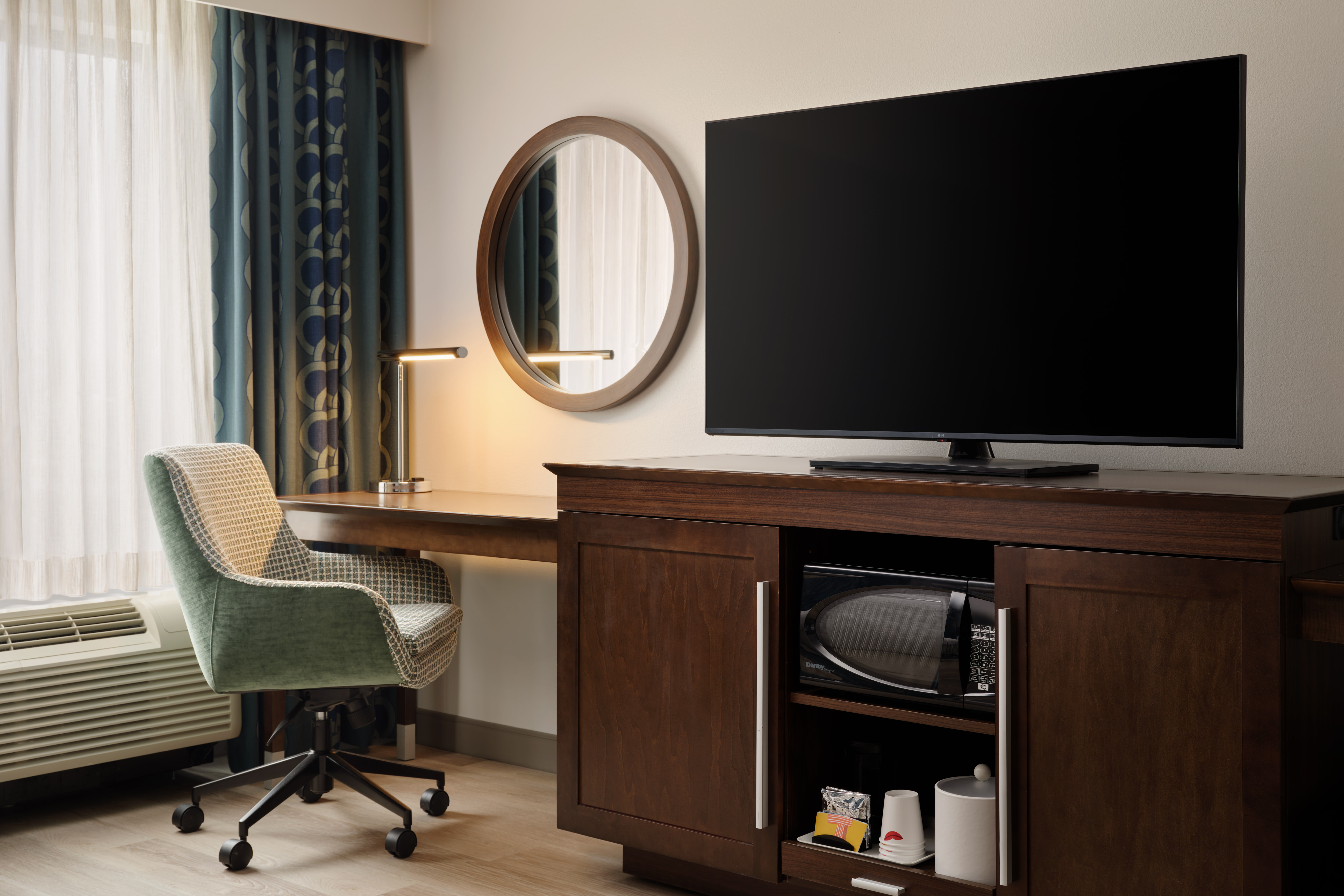 客房内的电视、微波炉、咖啡用品和工作书桌区