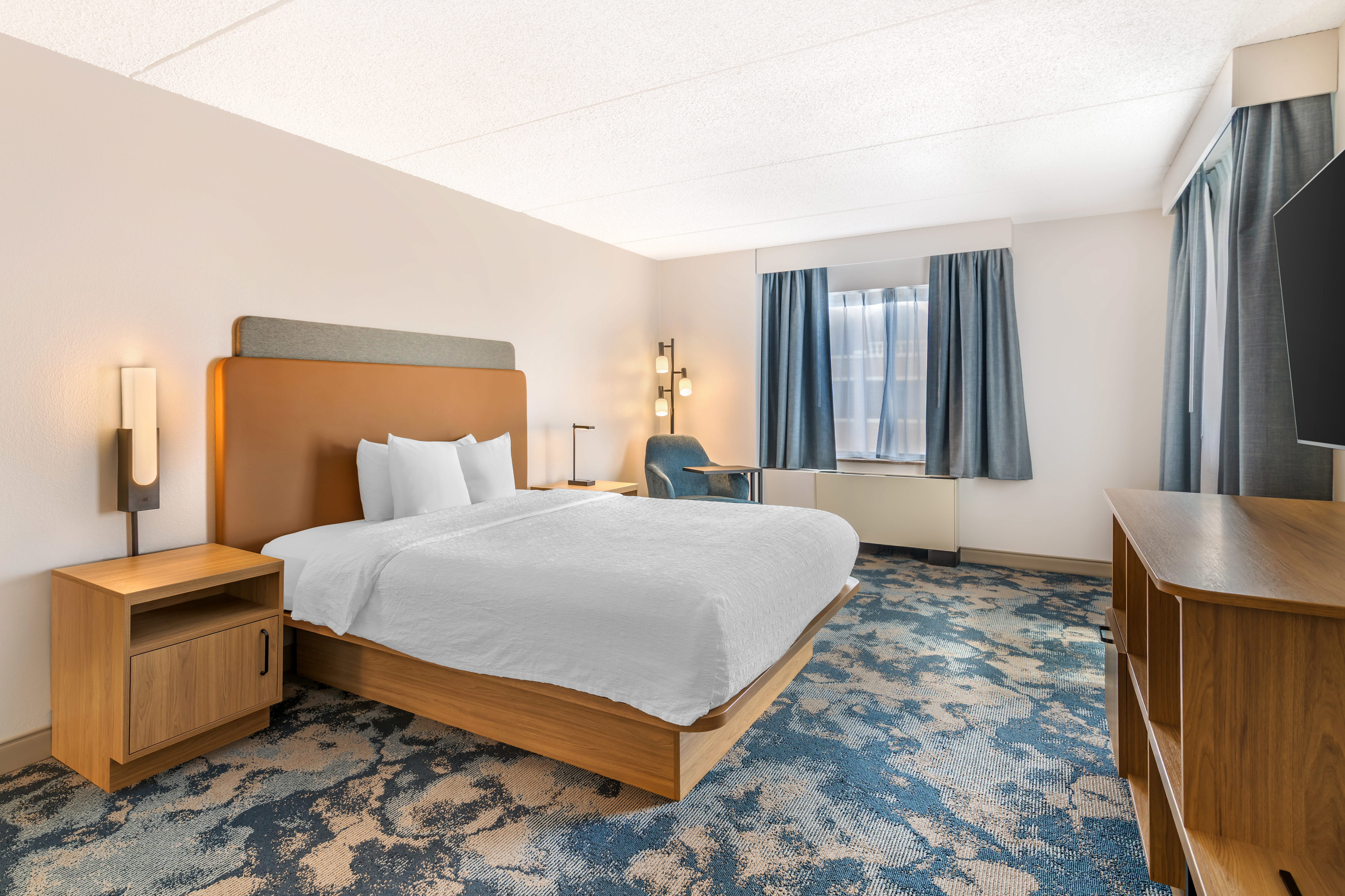 Comfortable suite bedroom with TV and chair