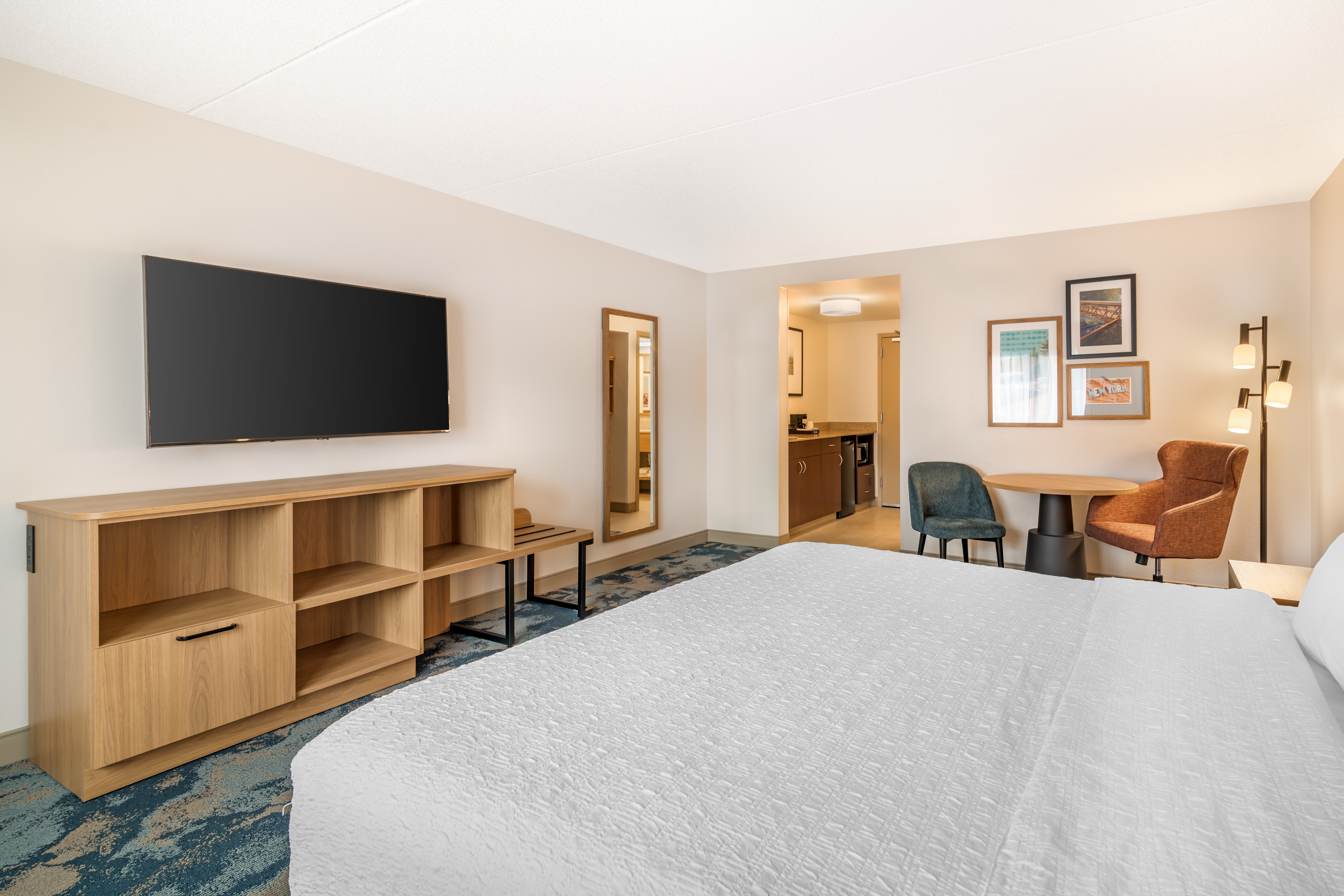 King bedroom with a TV and dining table with seating