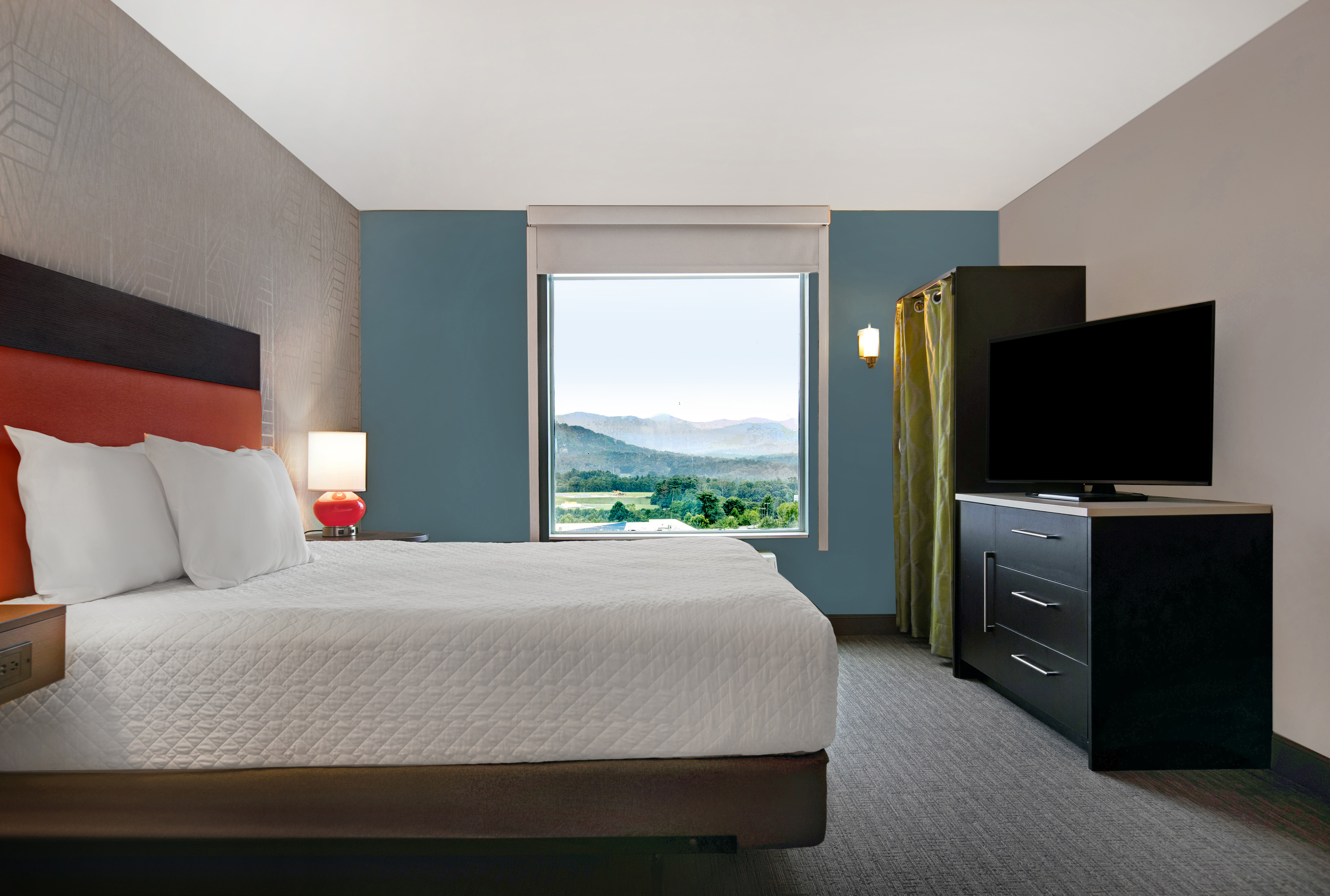 guest room with bed television and window with view