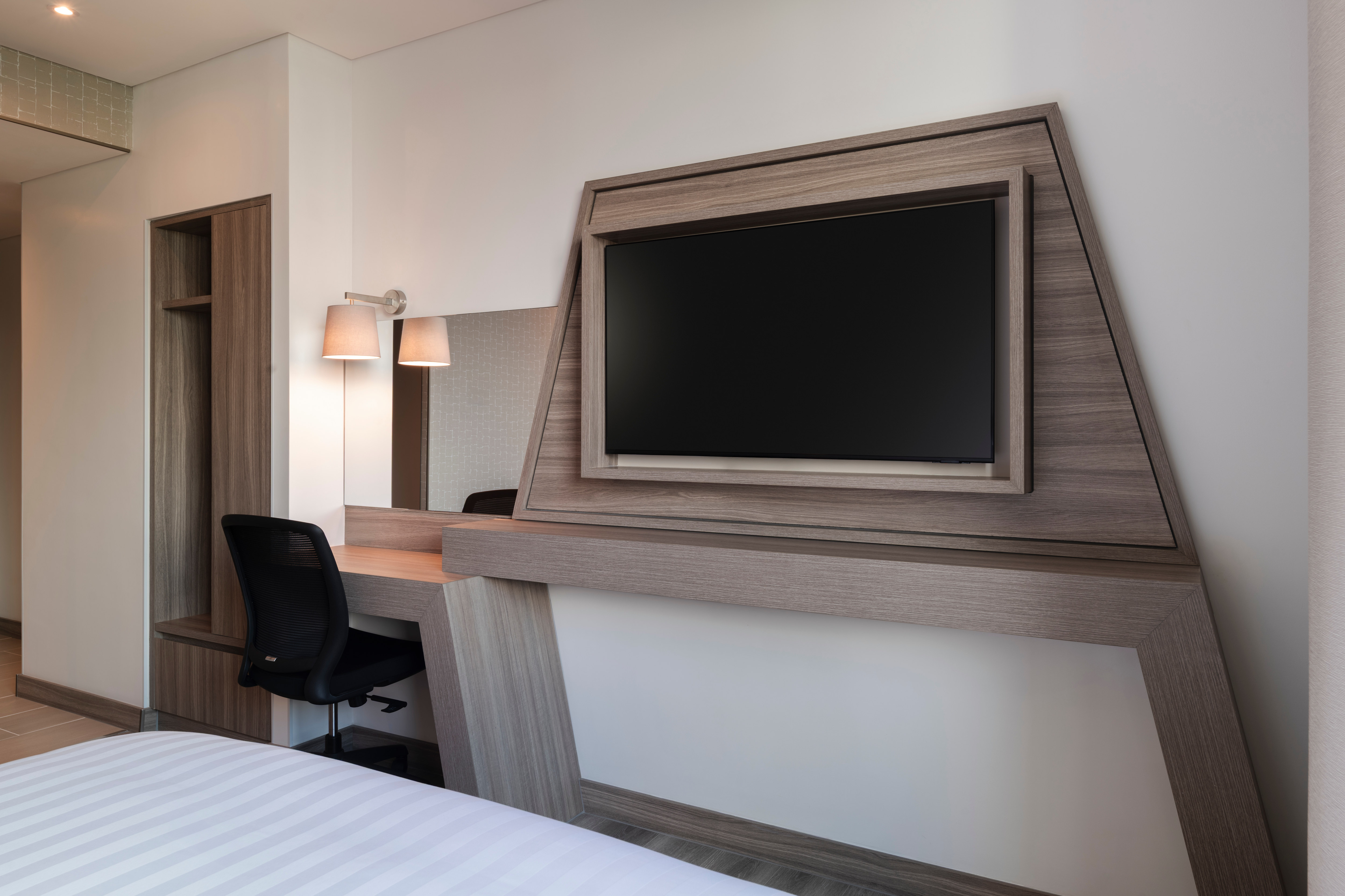 Guest Room with Work Desk, Chair, and TV on the Wall