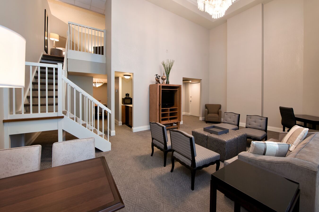 TV, Tables, Chairs, Sofa, and Staircase in Presidential Suite Living Area