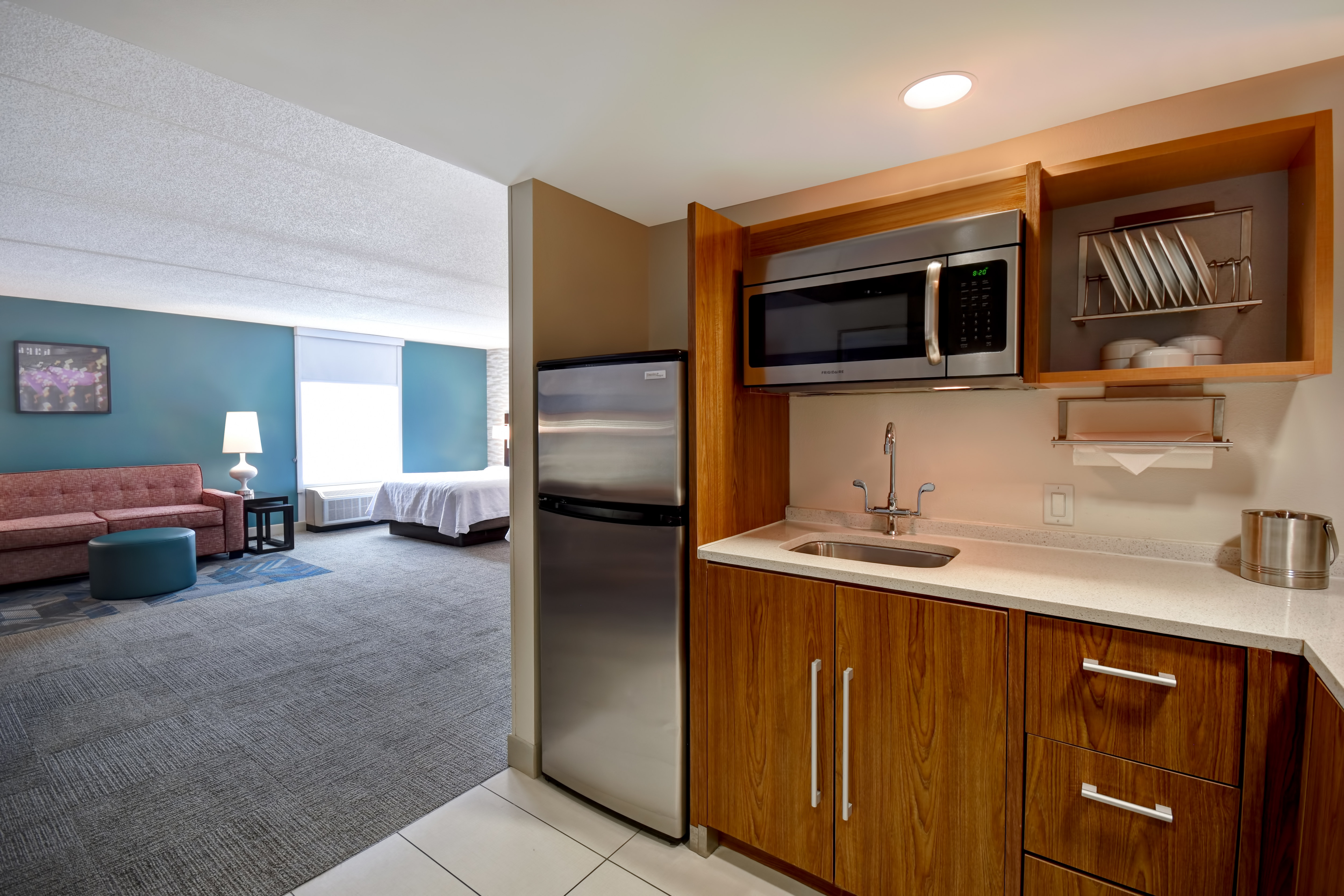 guest room with kitchen lounge area beds and window