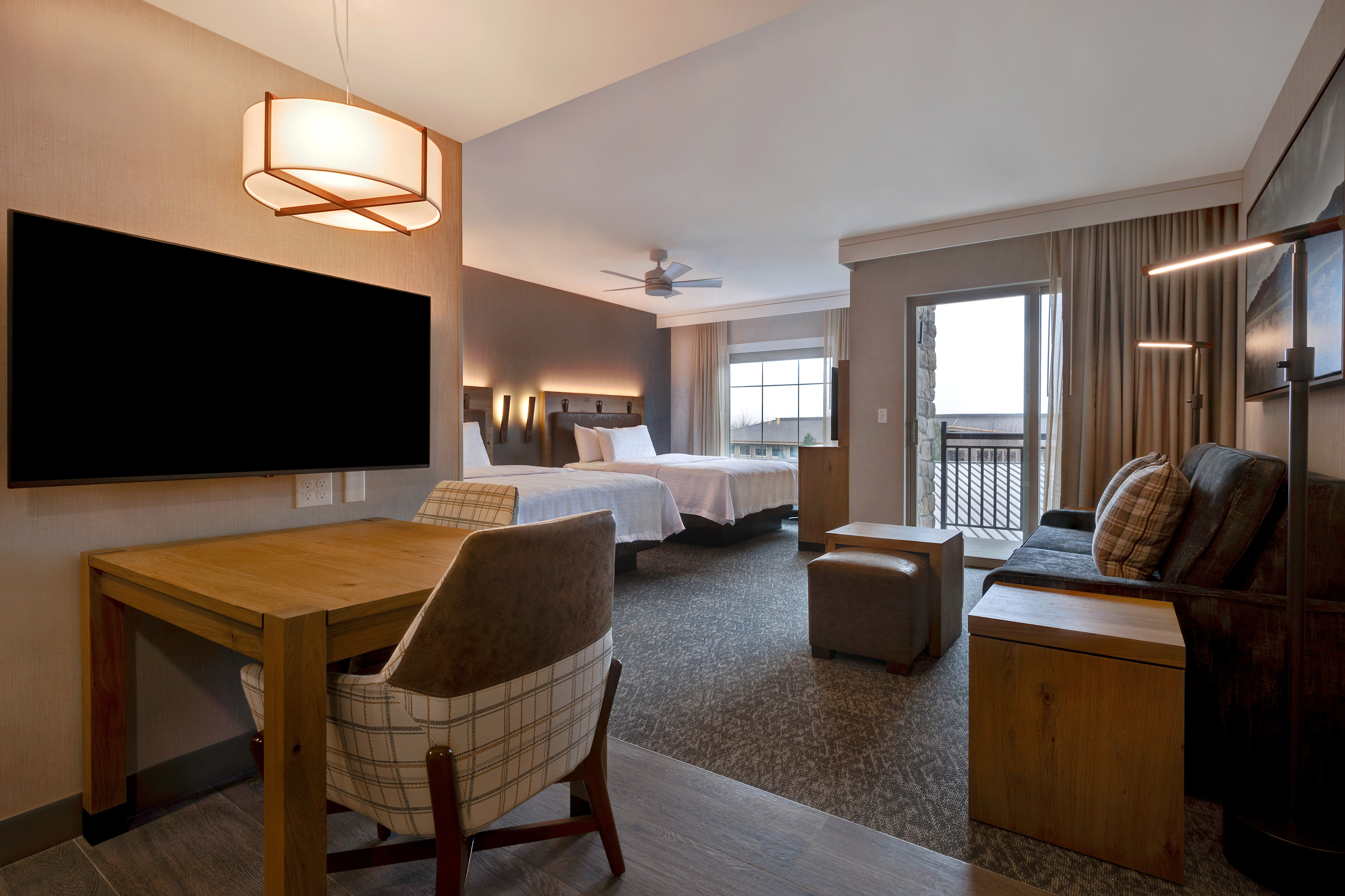 guest room lounge area balcony television and two beds