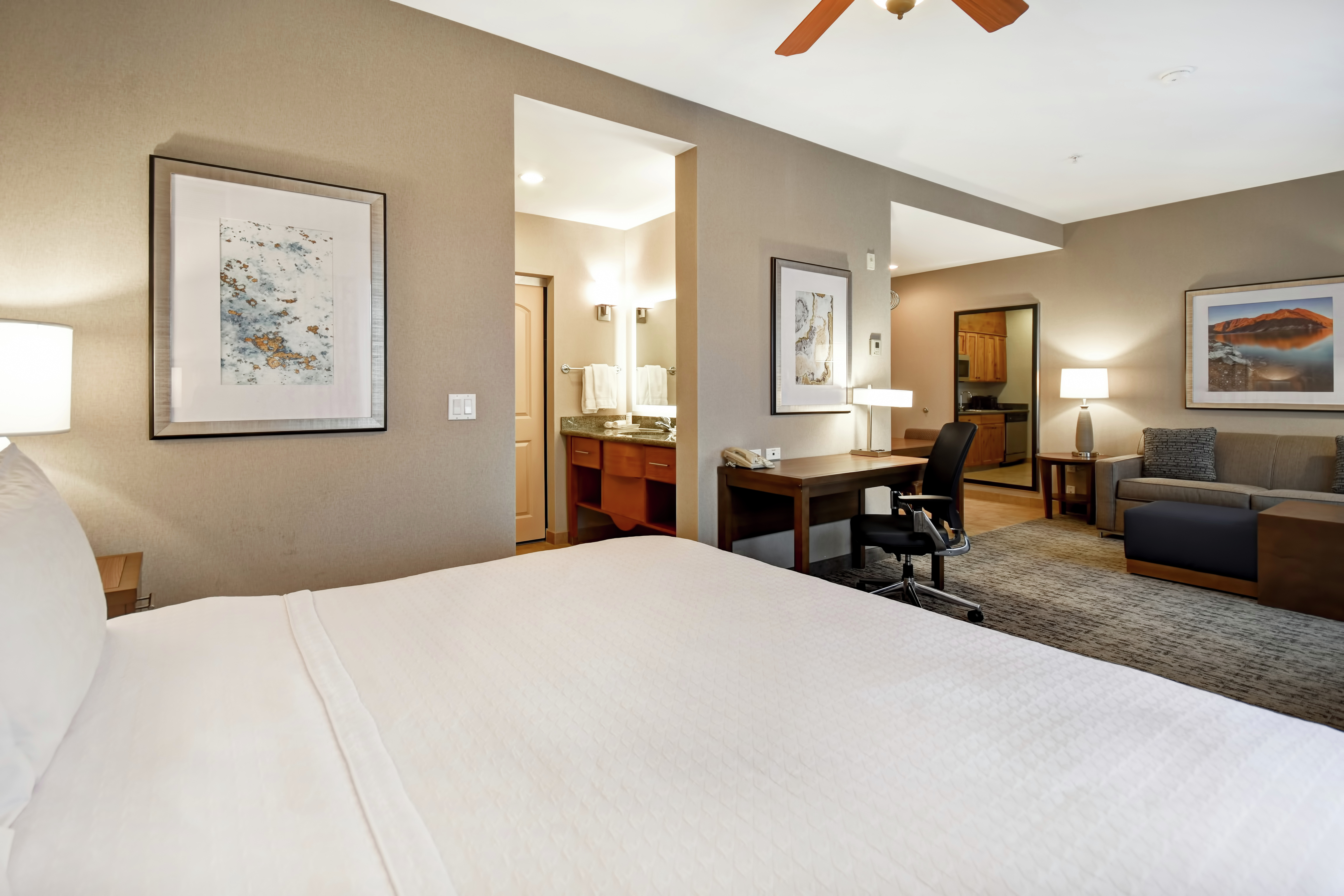 Bed, Work Desk, and Lounge Area in Suite
