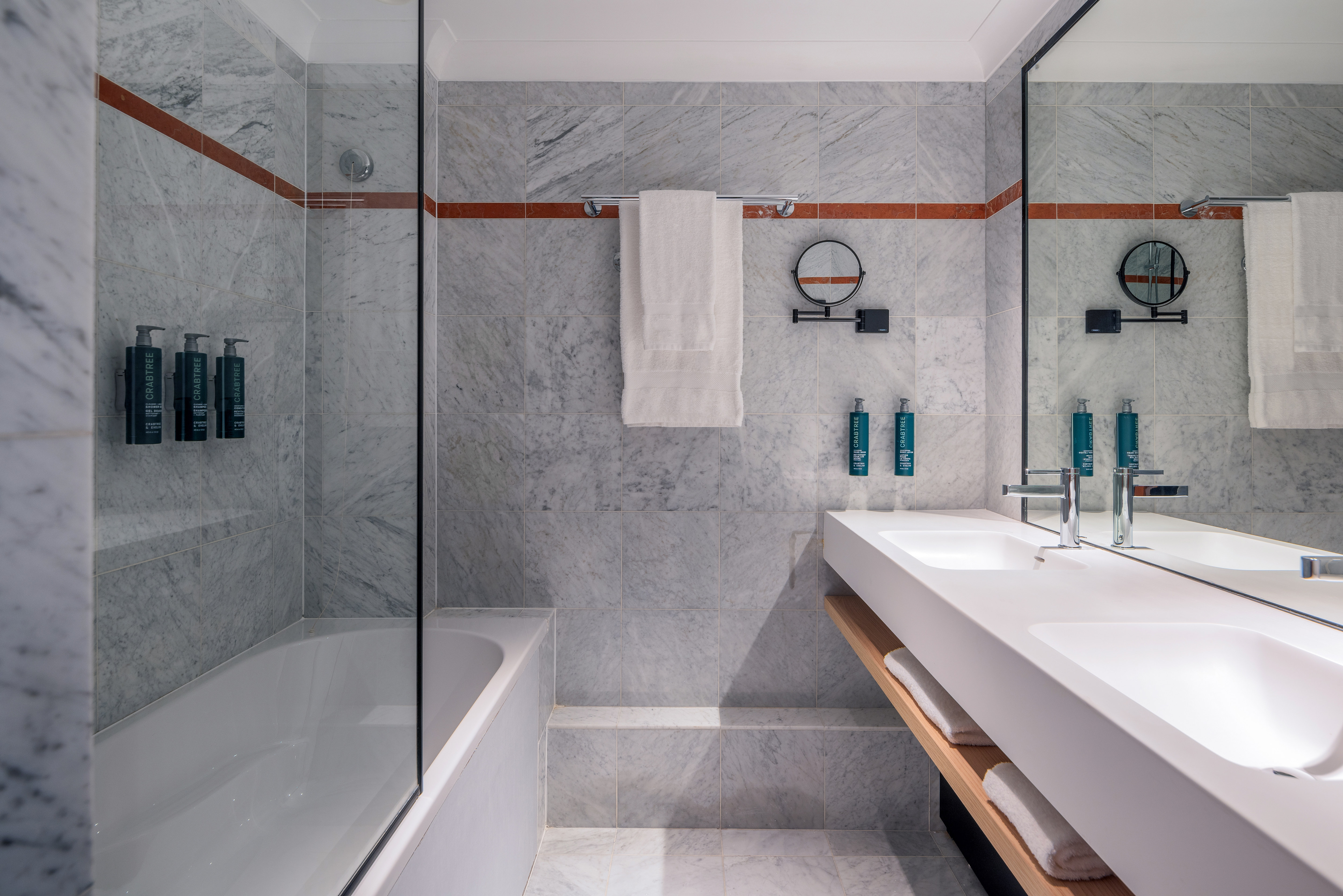 Bathroom with sinks, mirror and tub