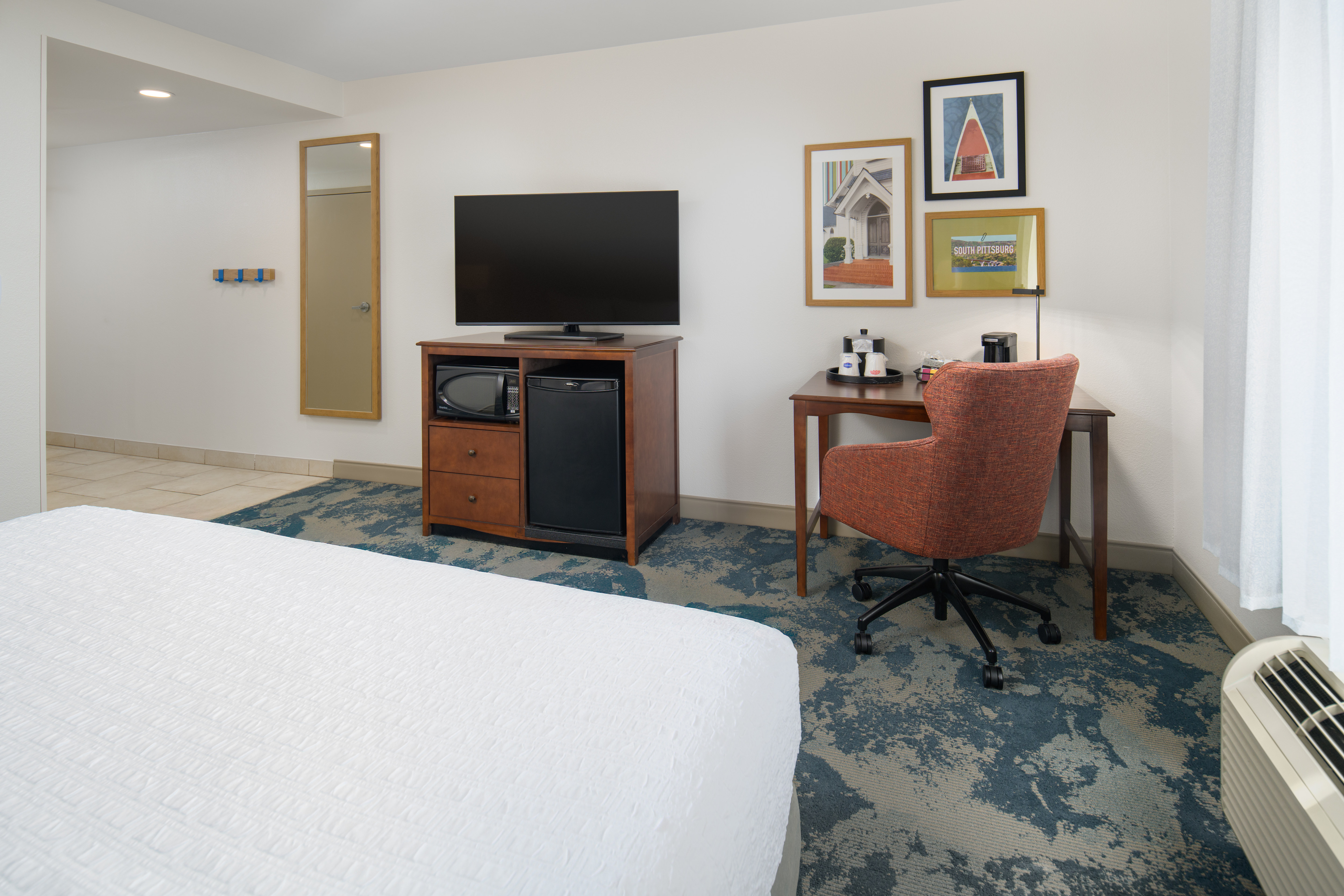 Large Bed, TV, Desk, Microwave and Mini Fridge in a Guest Room