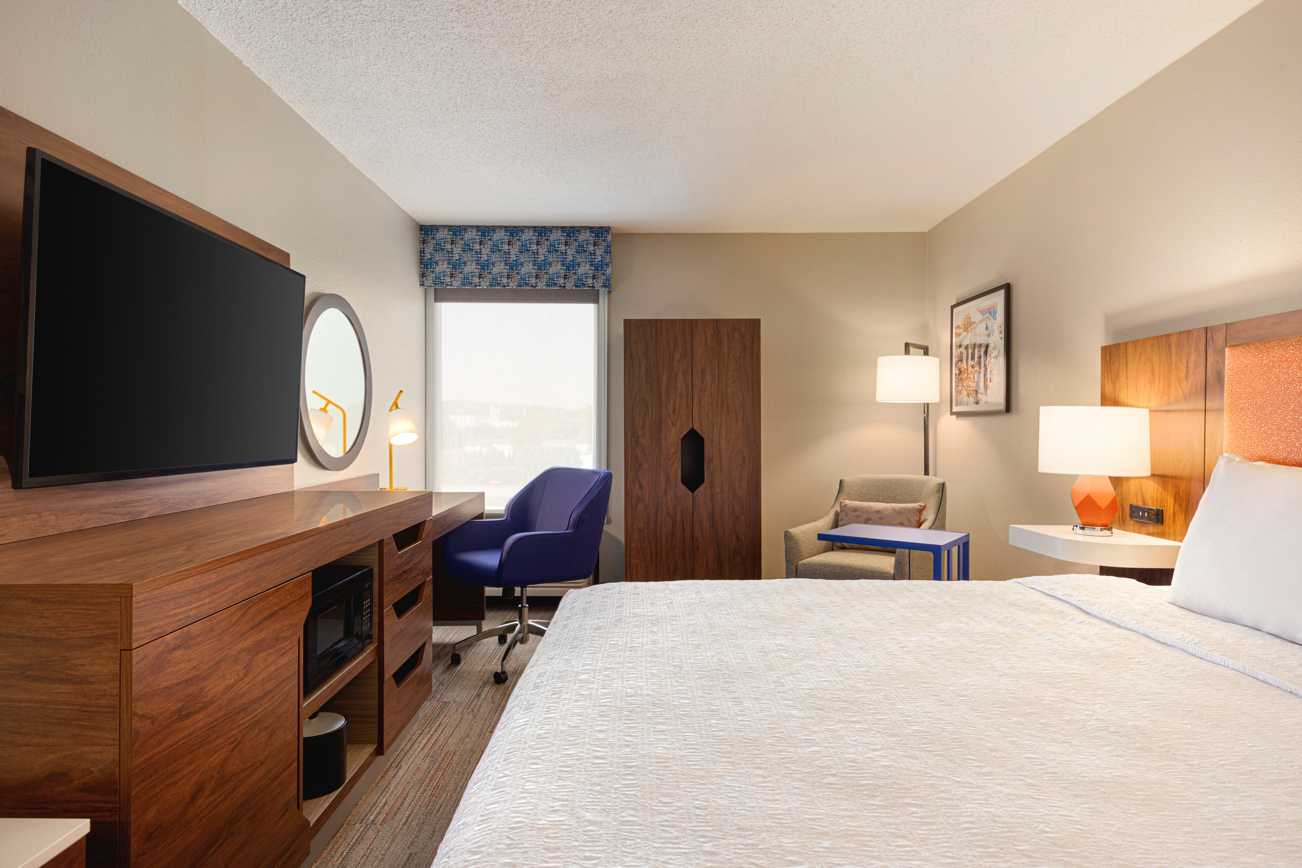 Spacious guest room featuring a king bed, TV, and convenient work desk