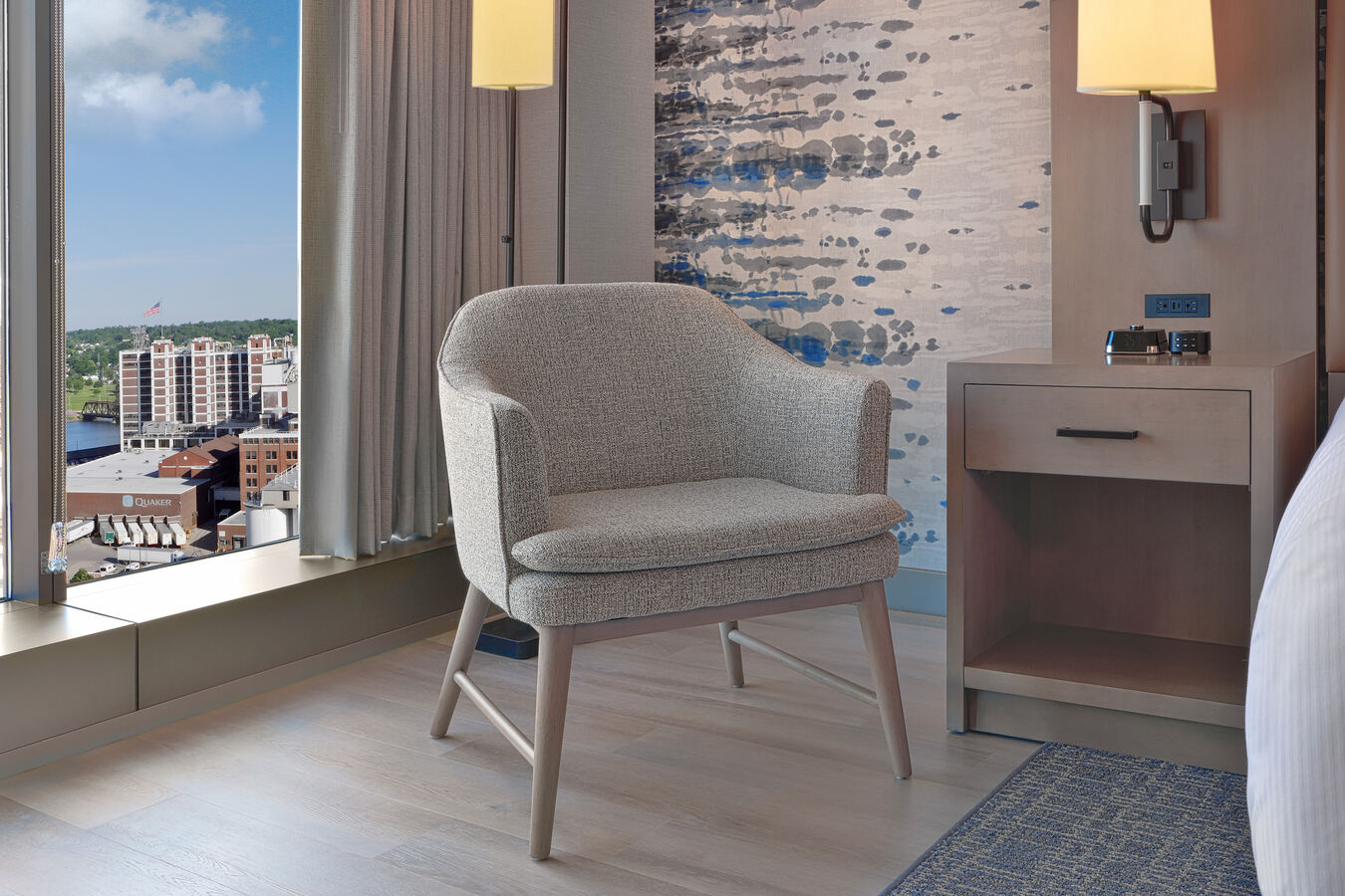 Comfortable seating near guest bed with city view