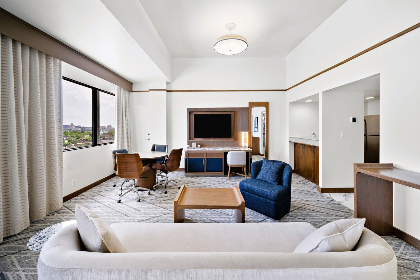 Suite Lounge Area with Wet Bar, Sofa, Dining Table, Work Desk, Chairs, and TV