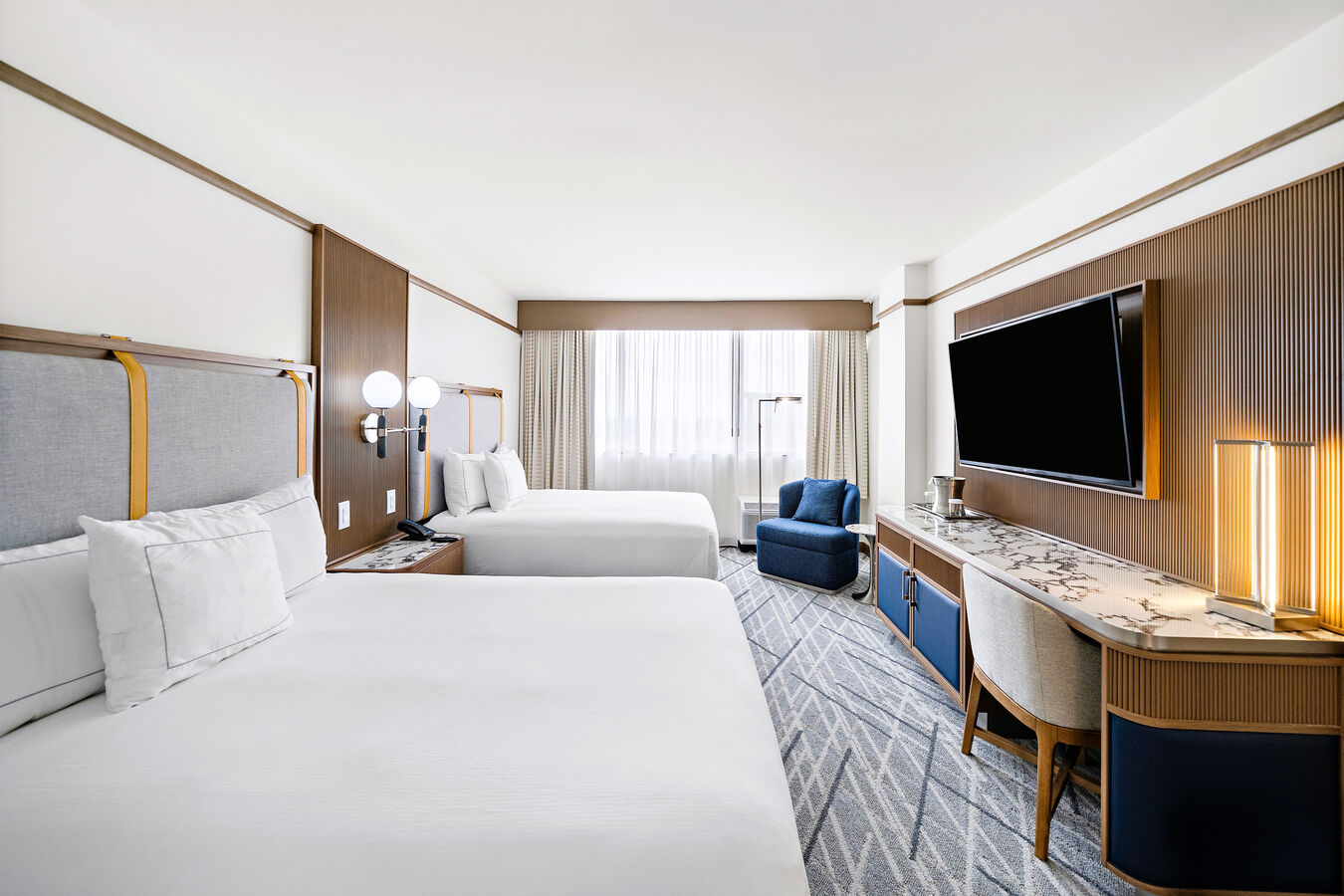 Guest Room with Two Queen Size Beds, Work Desk, Wall TV, and Sofa Chair
