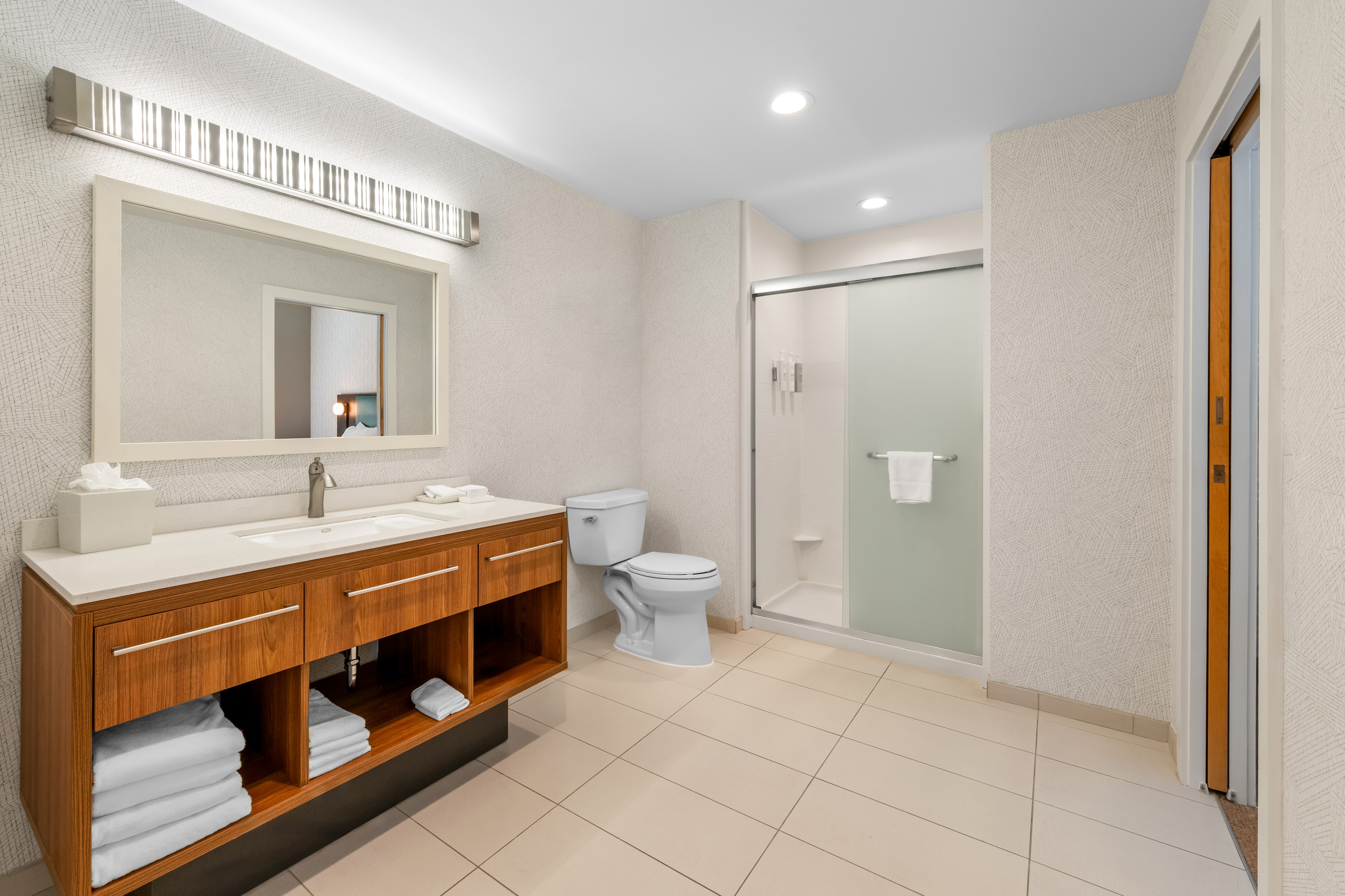 suite with sink, toilet, and walk-in shower