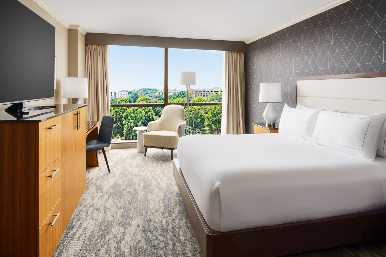 Guest room with one king bed, a sitting area, and floor-to-ceiling windows.