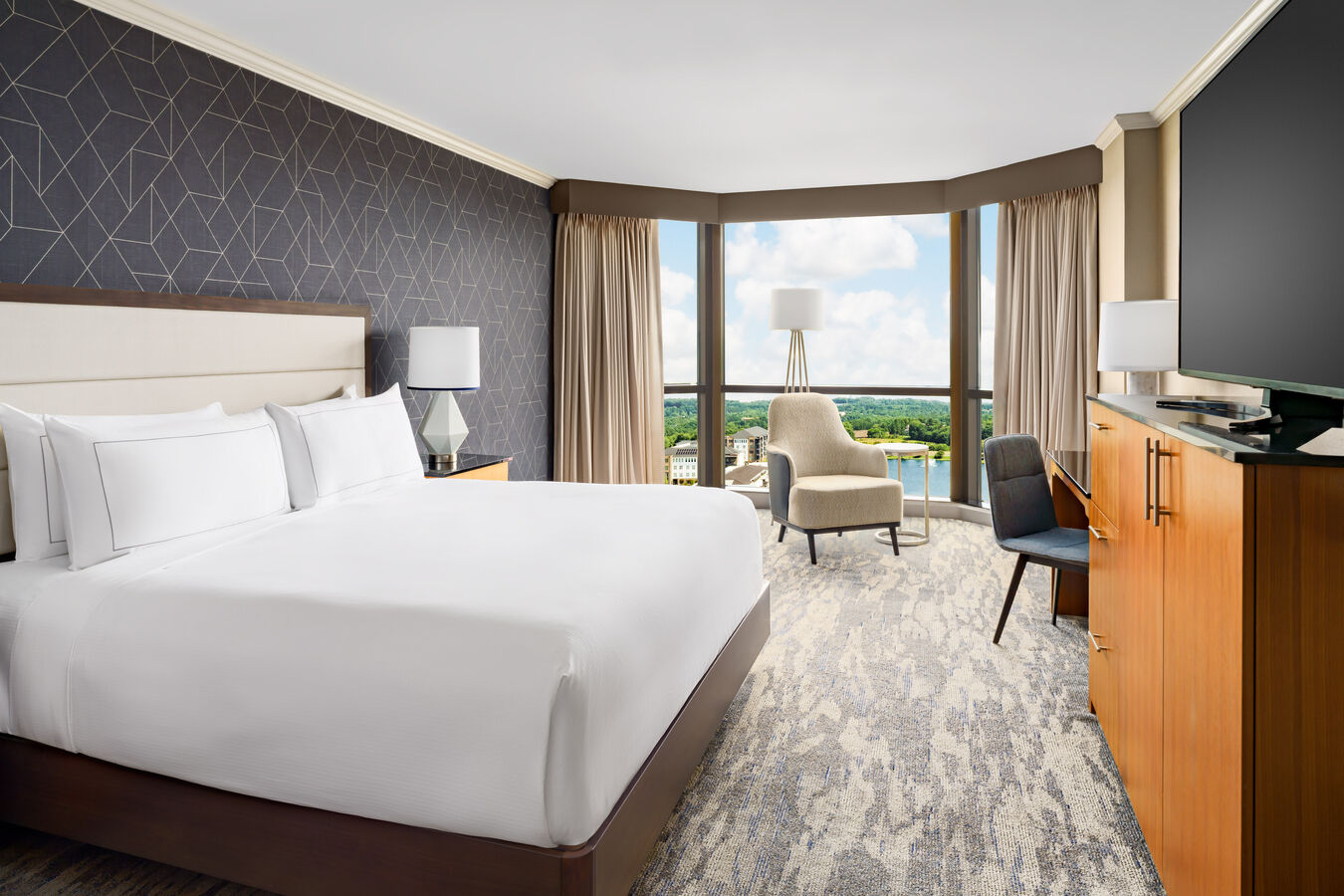 Guest room with one king bed, a sitting area, and floor-to-ceiling windows.