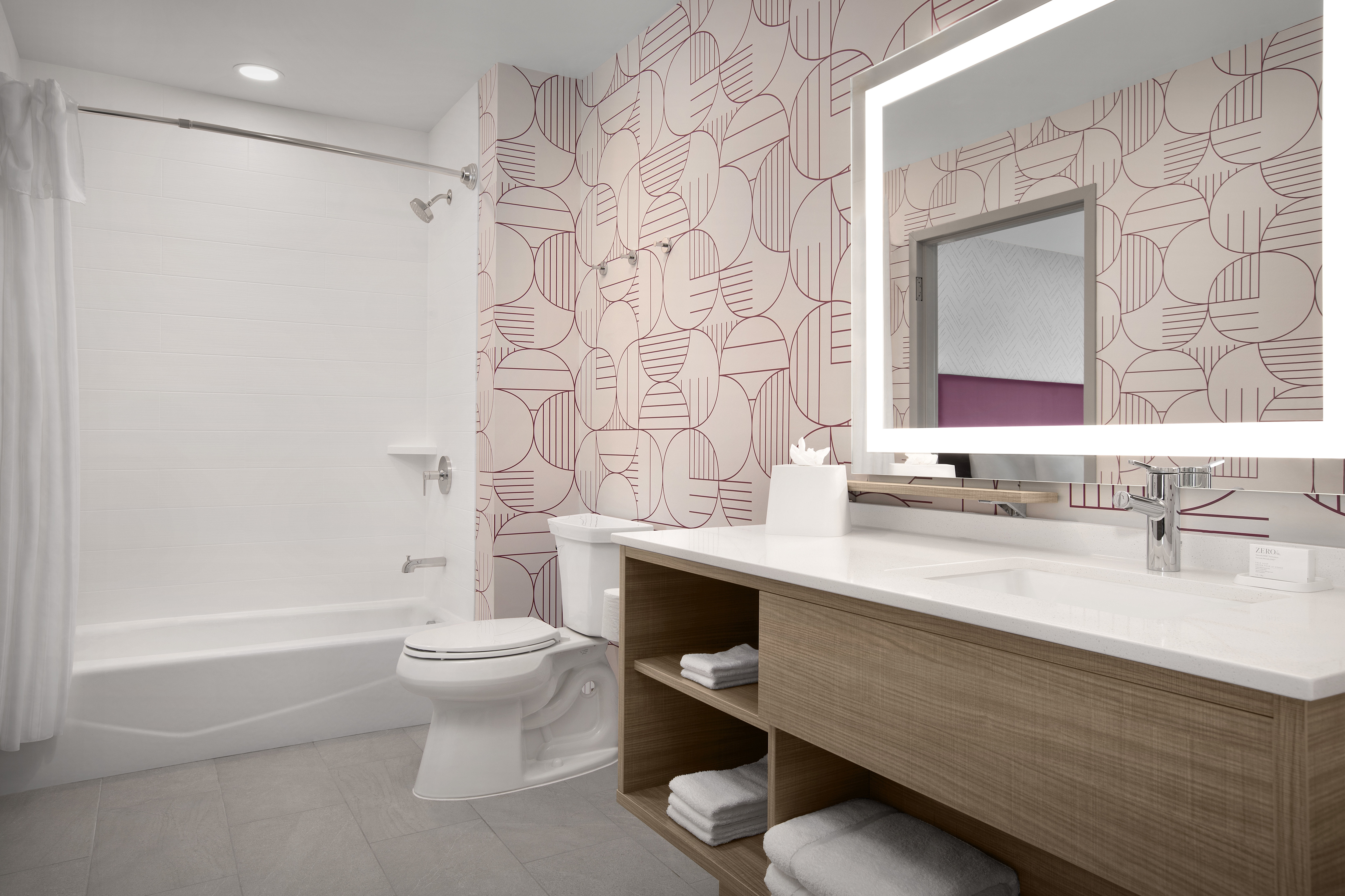 Guest bathroom with large vanity, lighted mirror and shower/tub