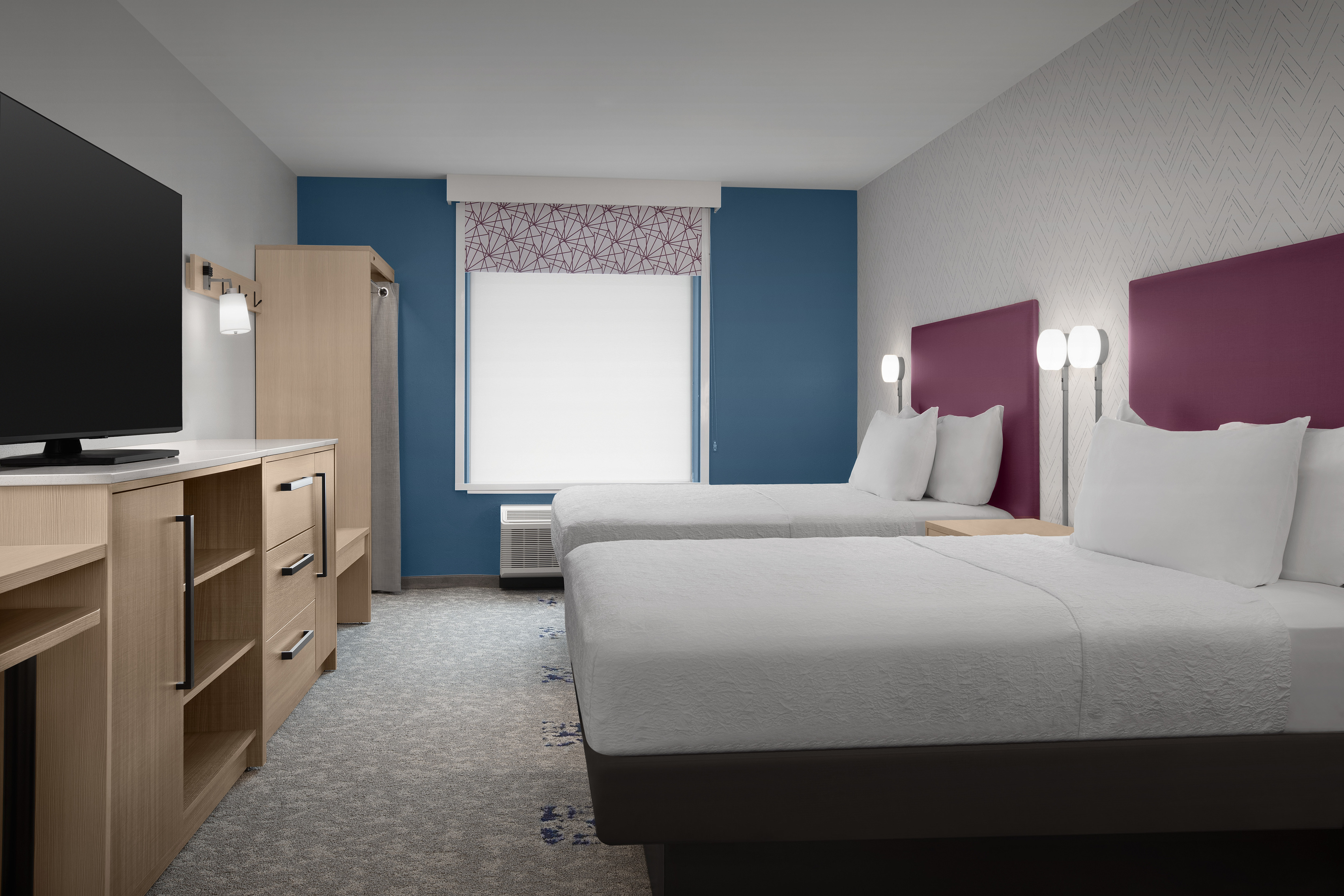 Suite bedroom with two queen beds, TV and storage