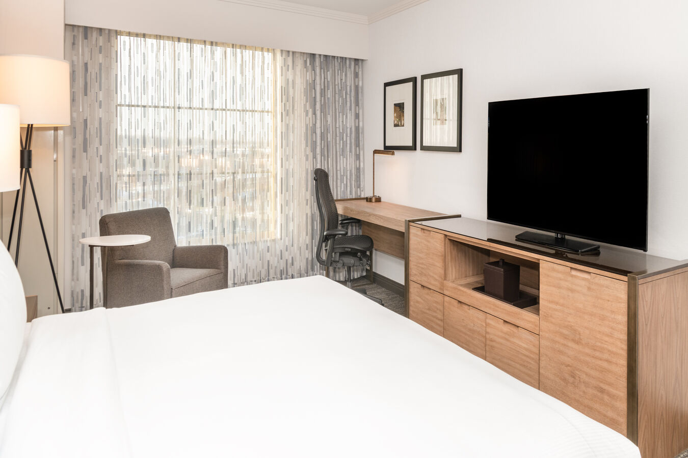 Large Bed in Guest Room with HDTV Desk and Armchair
