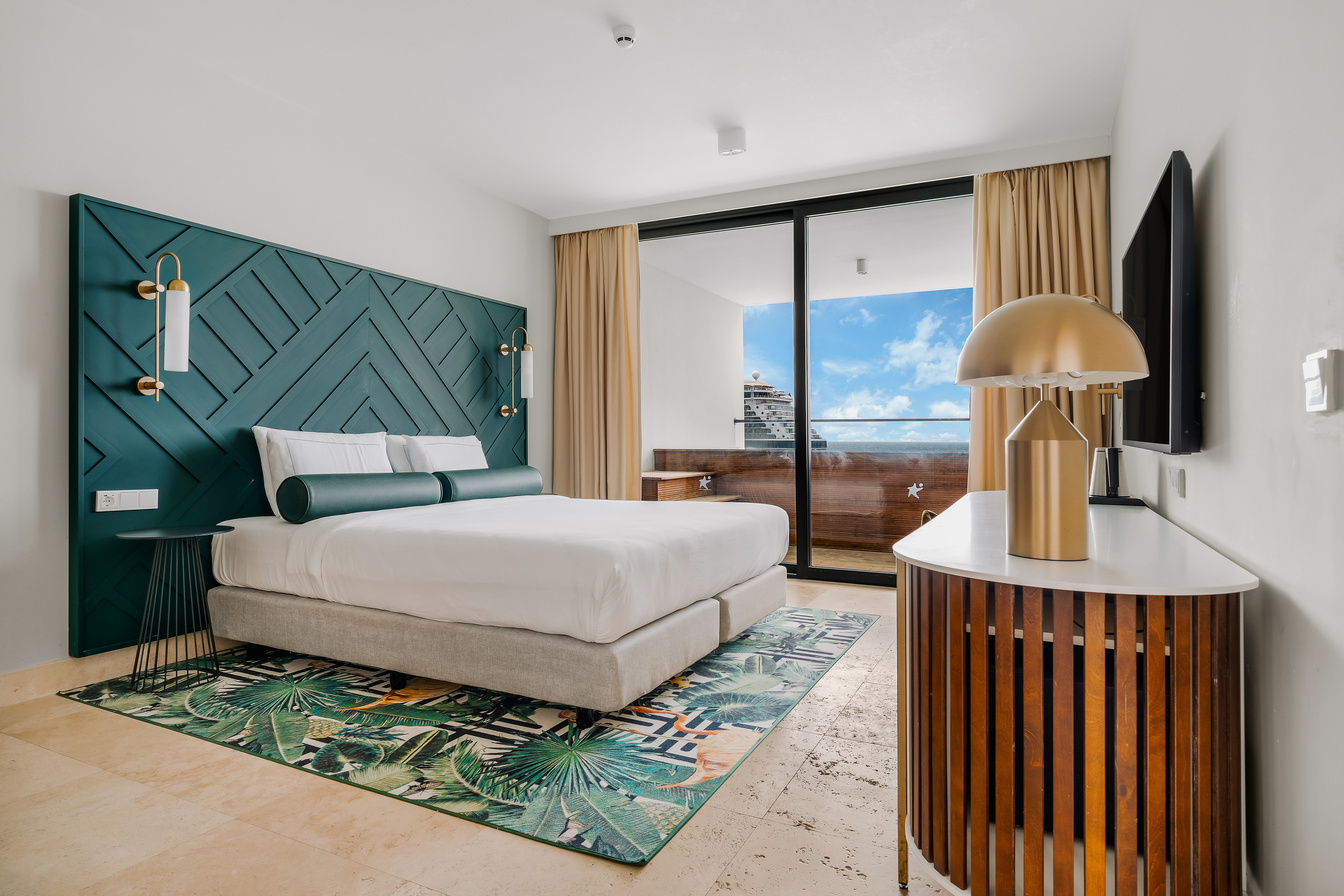 Bed view with green headboard and view of outside