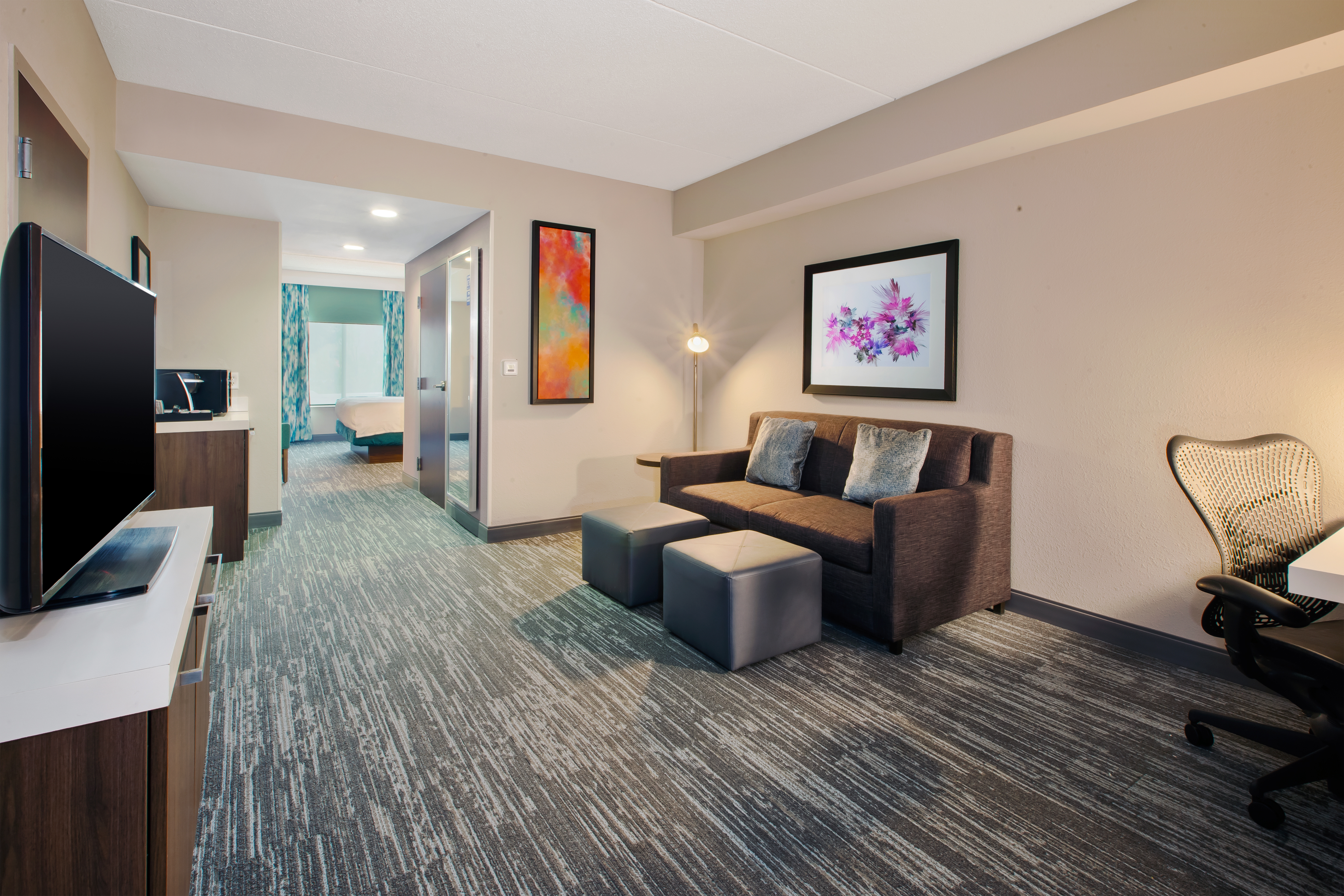 guest suite lounge area, sofa, ottomans, tv