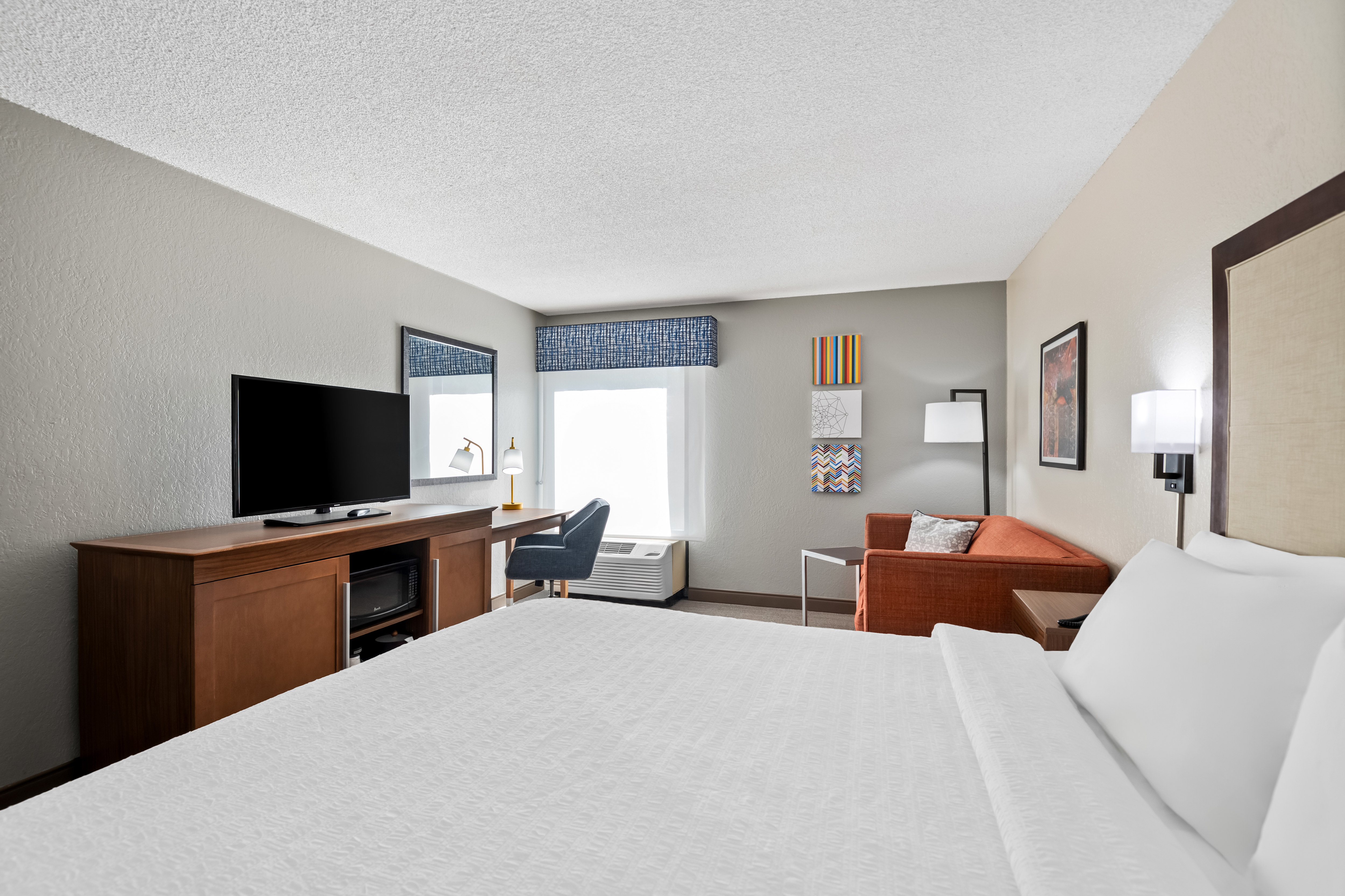 guestroom with king bed on right and media area on left