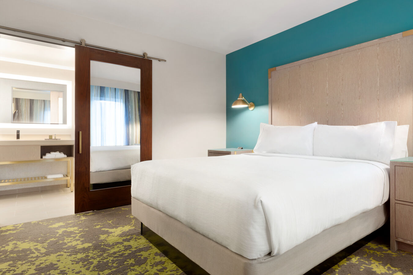 King Room Sleeping Area with King Bed and Bathroom Area with Large Vanity and Sliding Barn Door