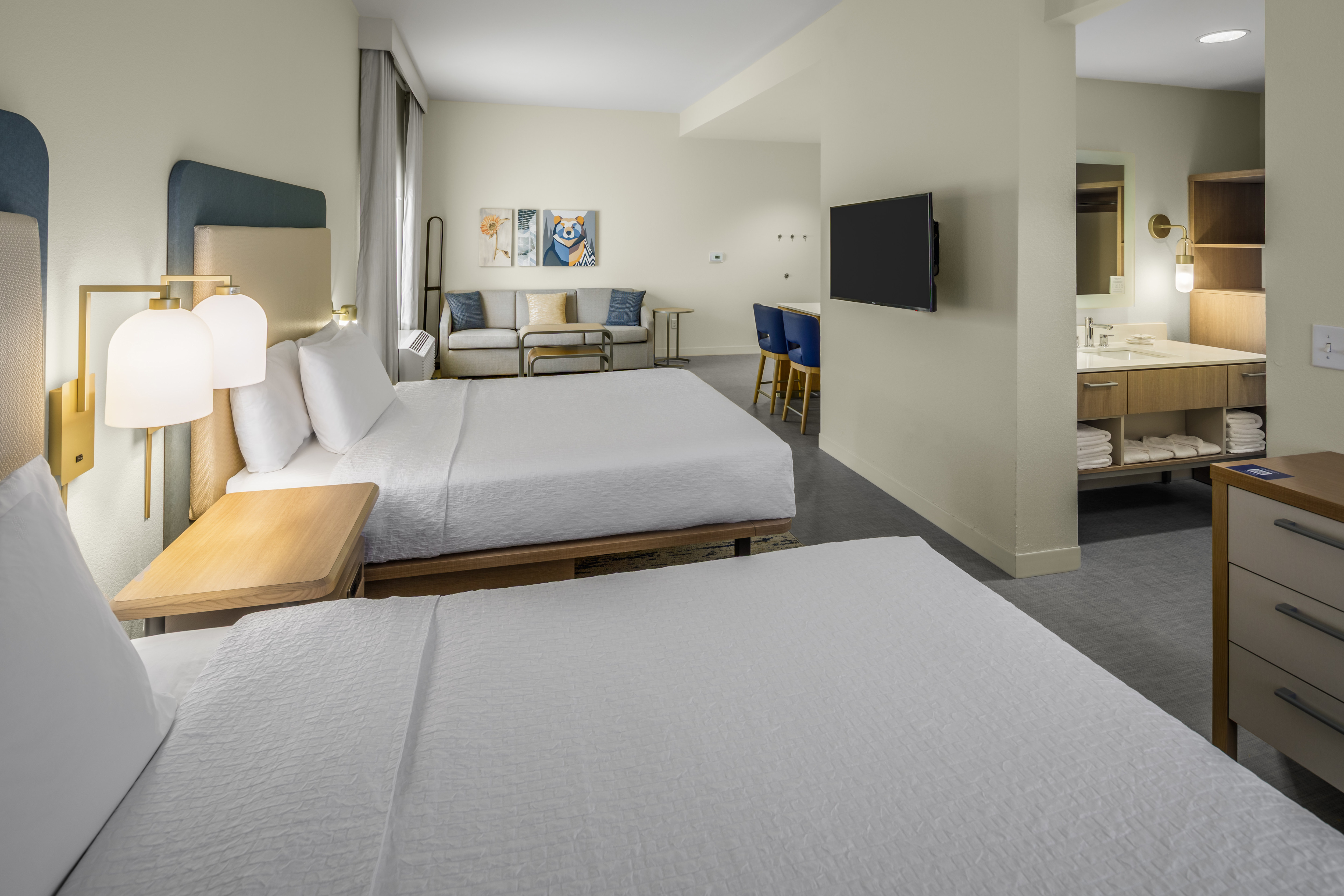 Two queen beds in a suite with TV and couch