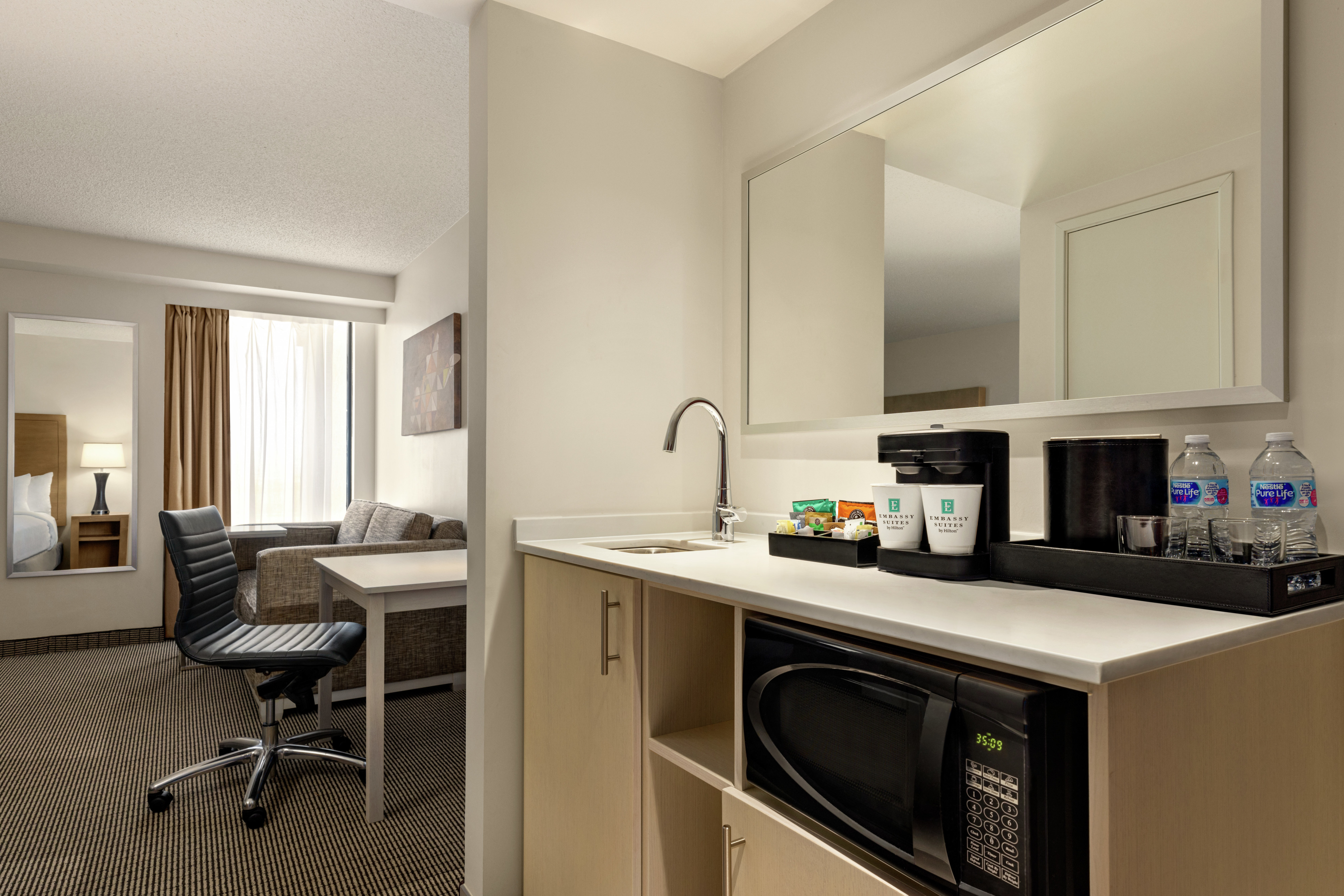 Spacious studio featuring convenient in-room wet bar, work desk, and sofa.
