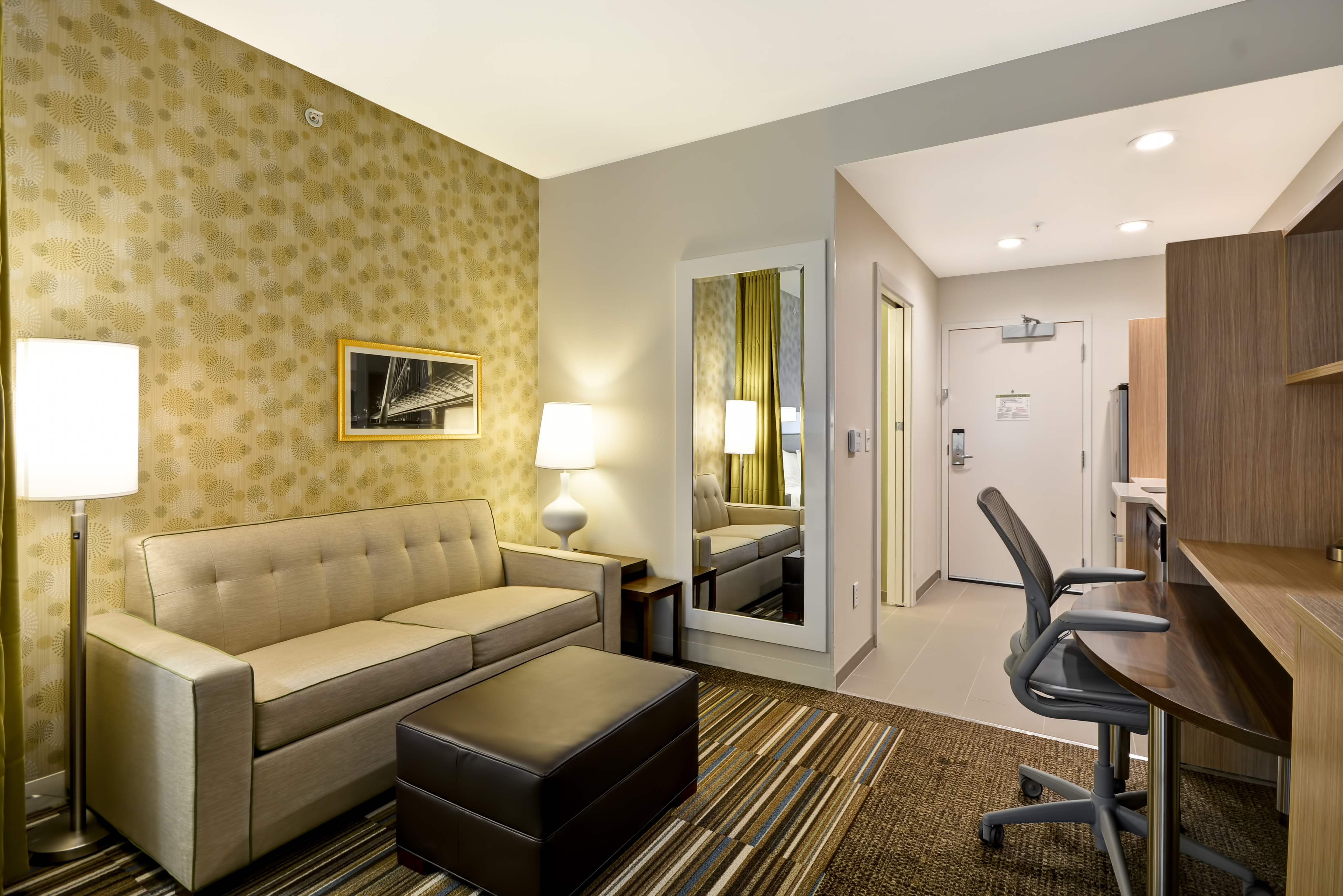 帶沙發、腳凳和工作桌的客房套房客廳