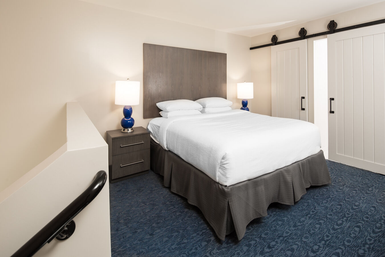 Bed in room with lamps and staircase