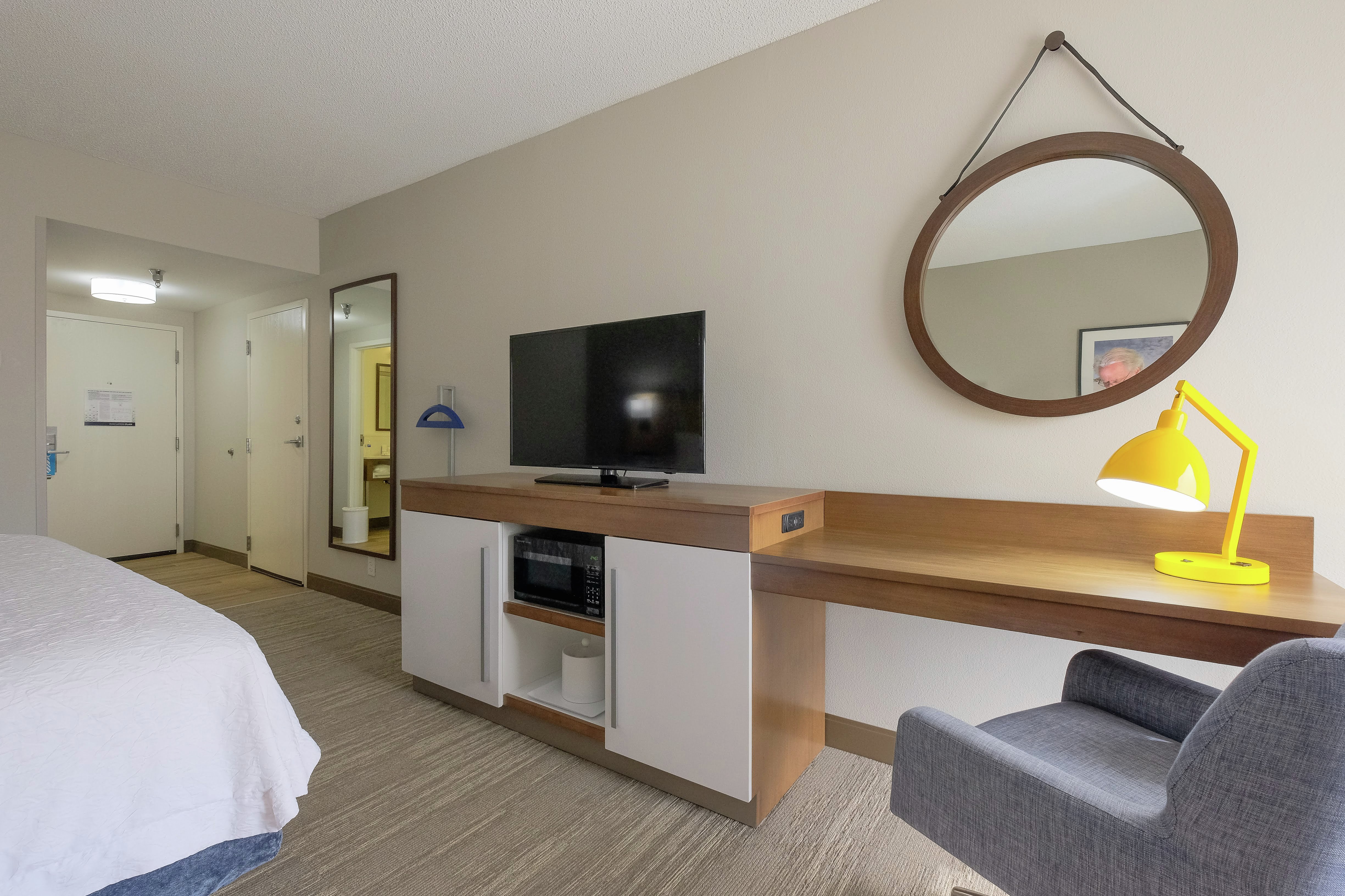 Flat Screen TV and Work Desk with Desk Lamp and Chair in King Guest Room