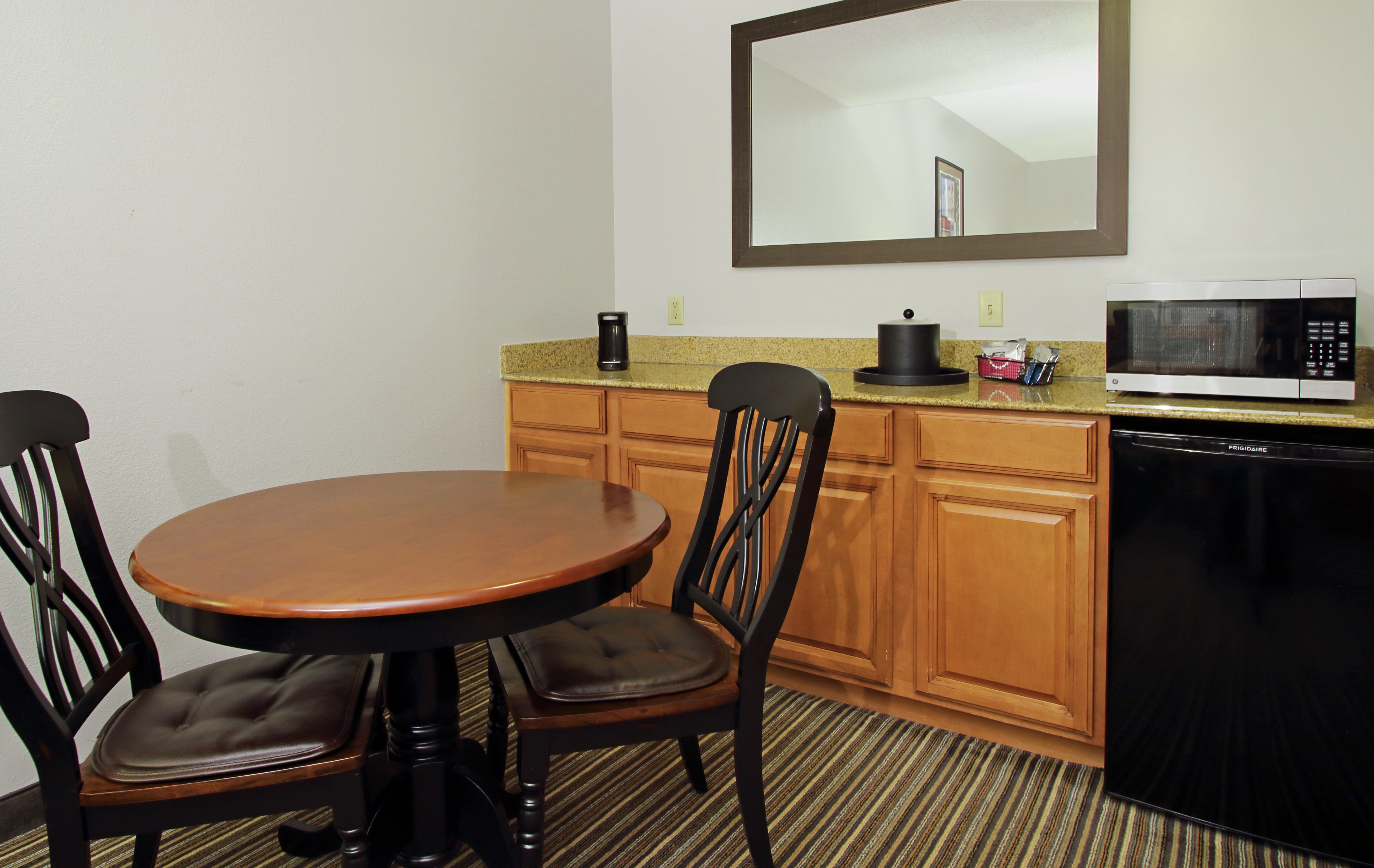 Suite guest room with bed, TV and work desk.
