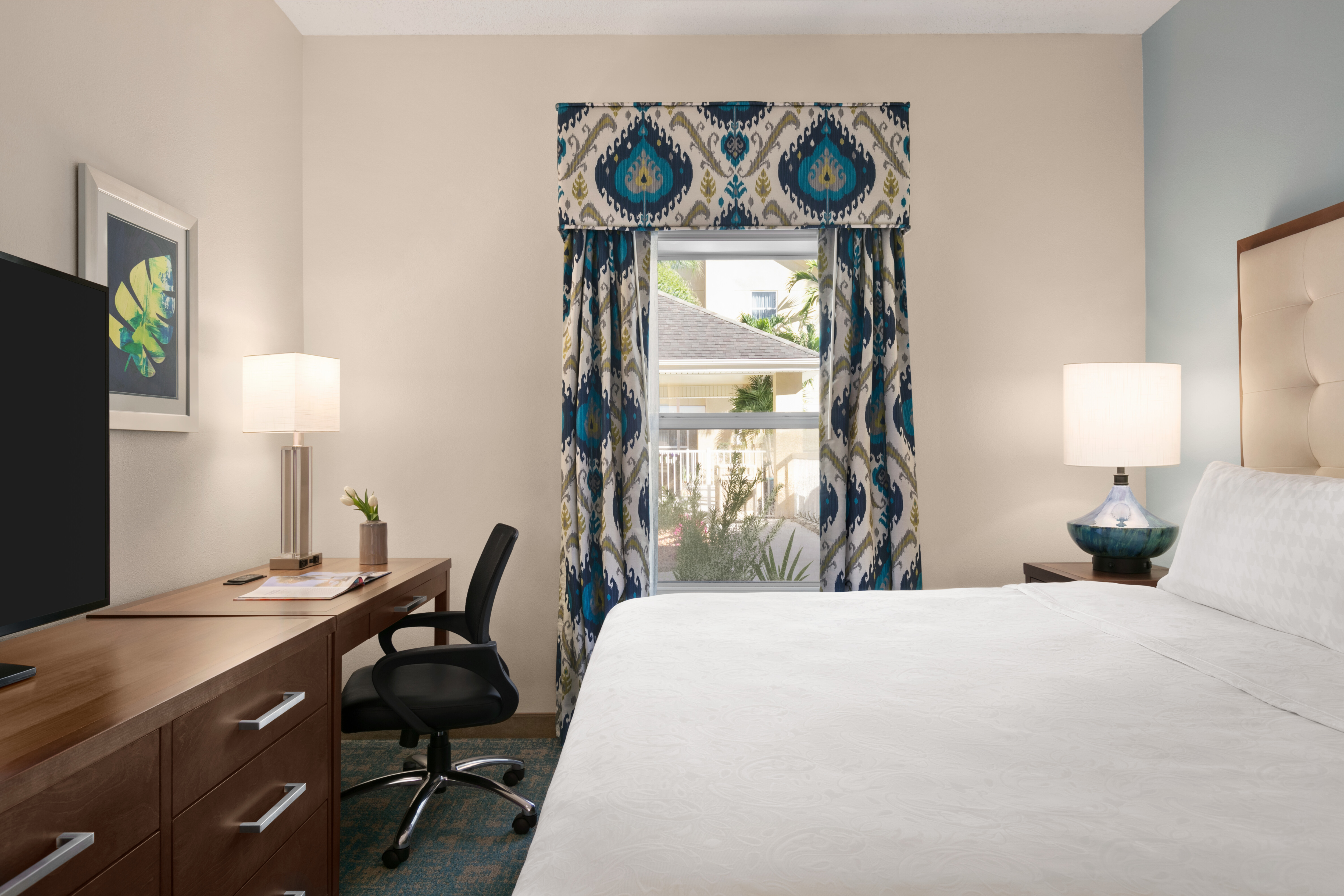 Bed in room with workdesk and window