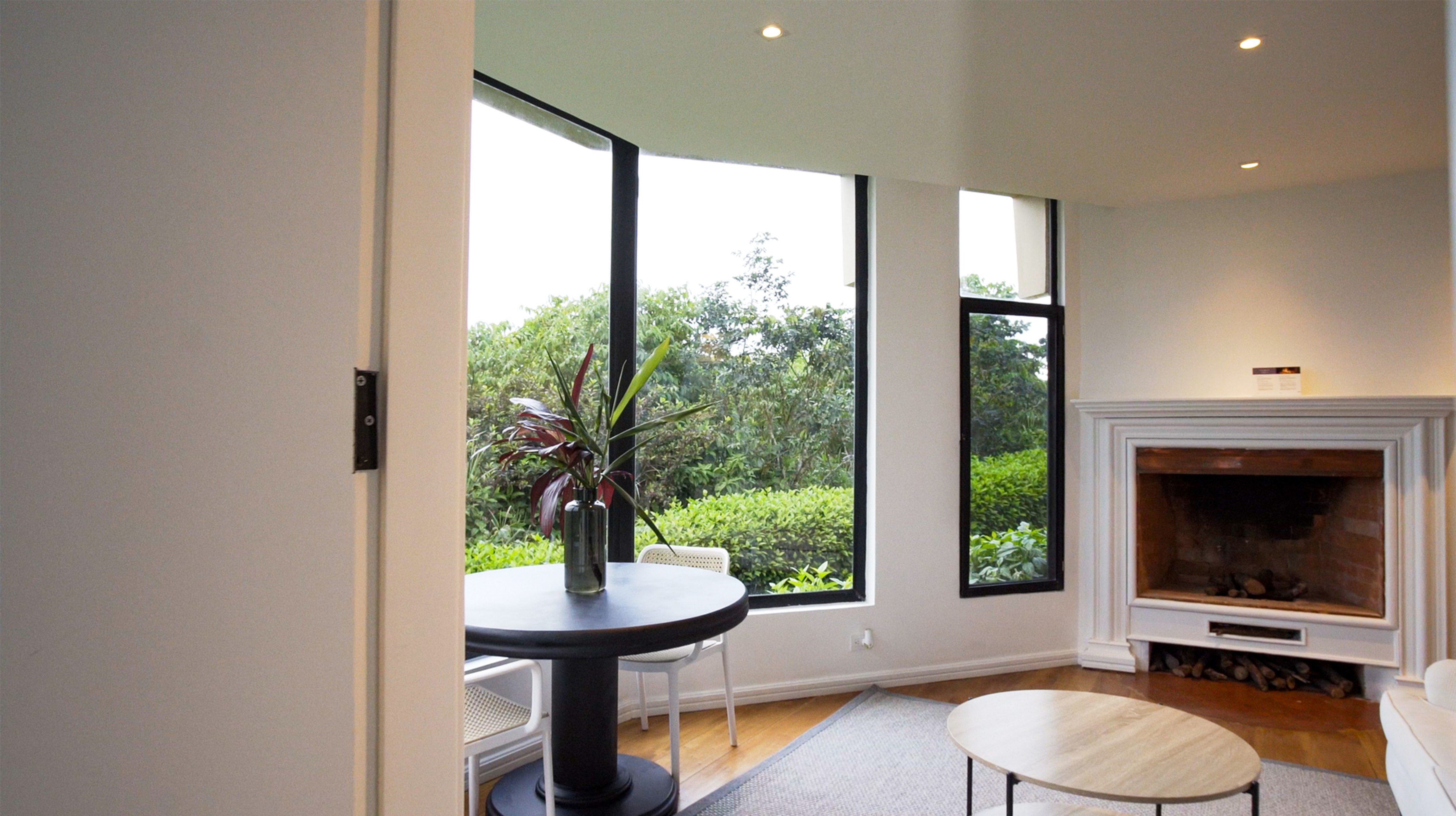 Living area with sofa, fireplace and windows.