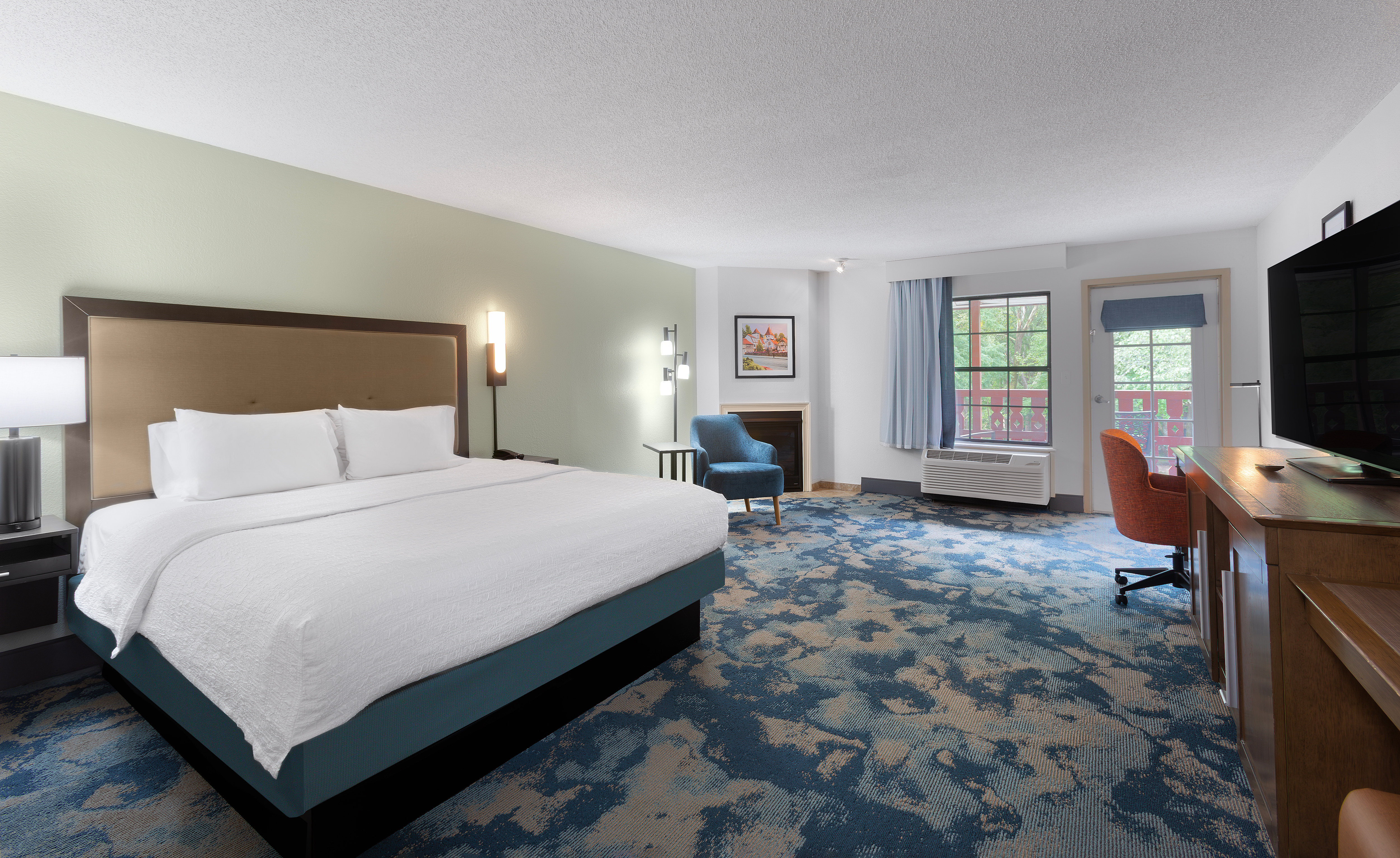 Single bed guest room with work desk and an exterior door