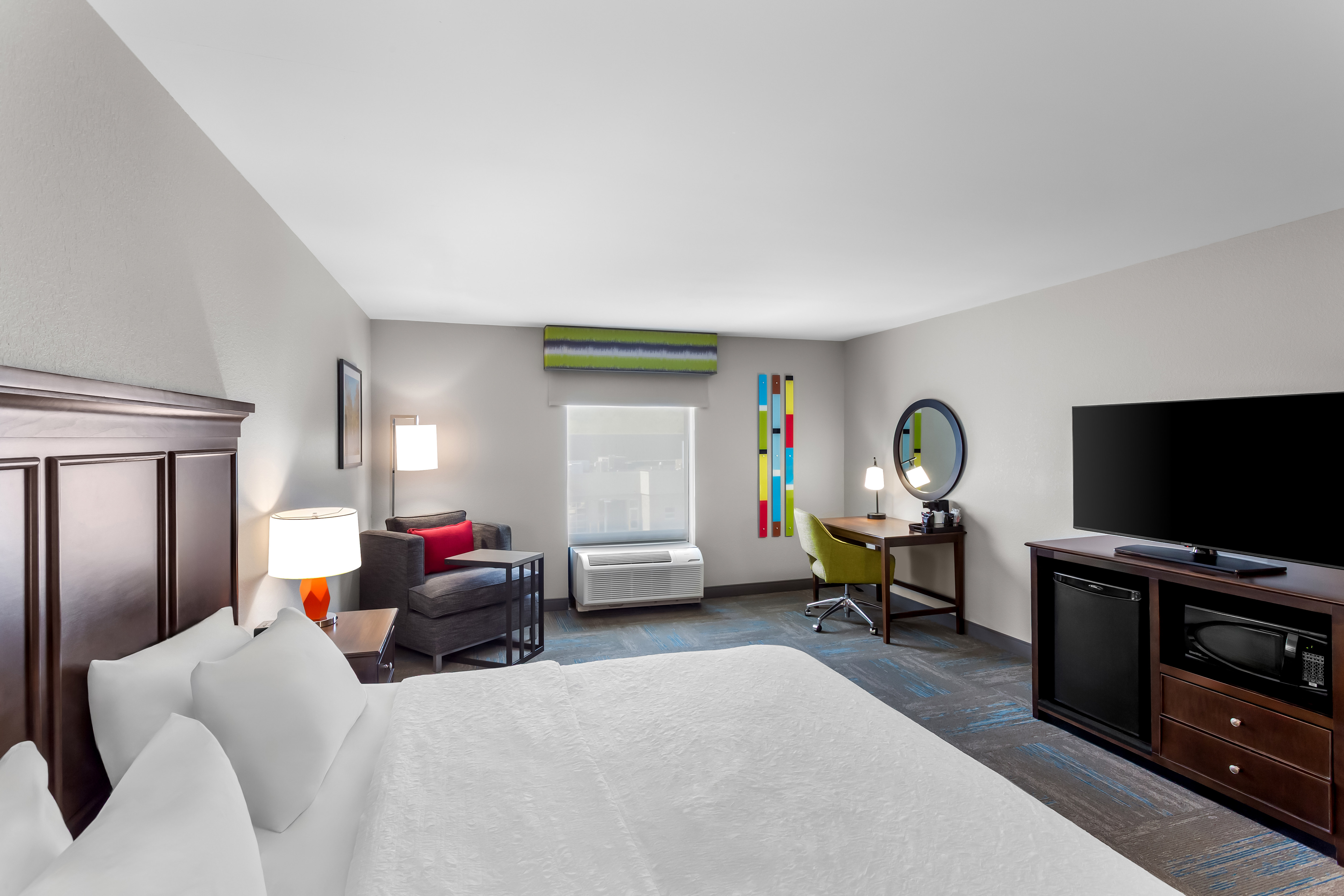accessible bedroom with king bed, chair, work desk, and tv
