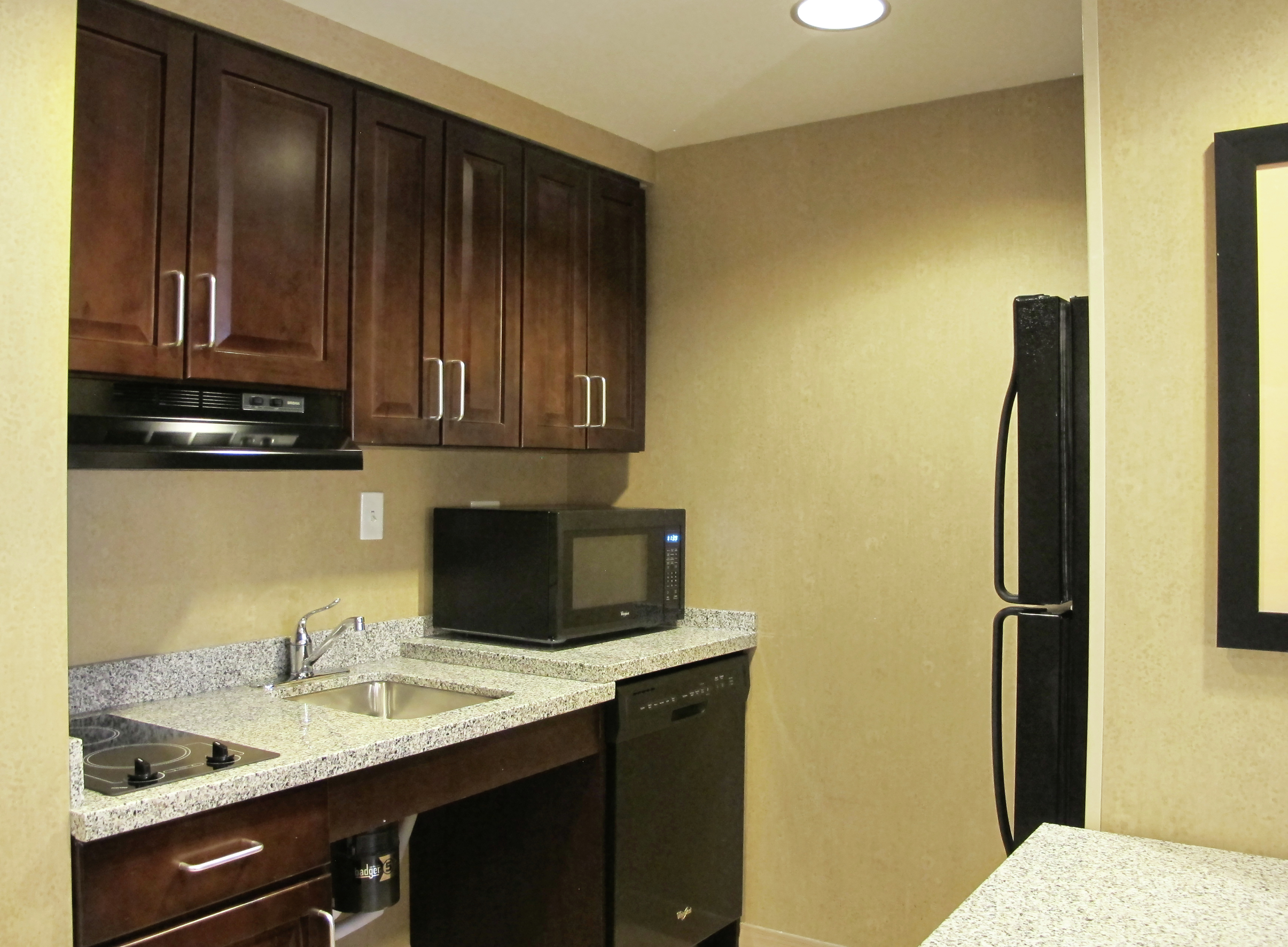 A Kitchen with Dark Wood Cabinets and a Microwave Oven on an Accessible Counter