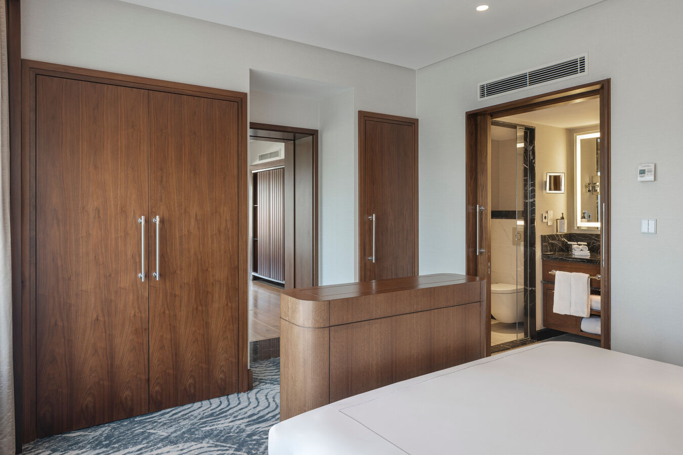 Bed in room with closet and view of bathroom