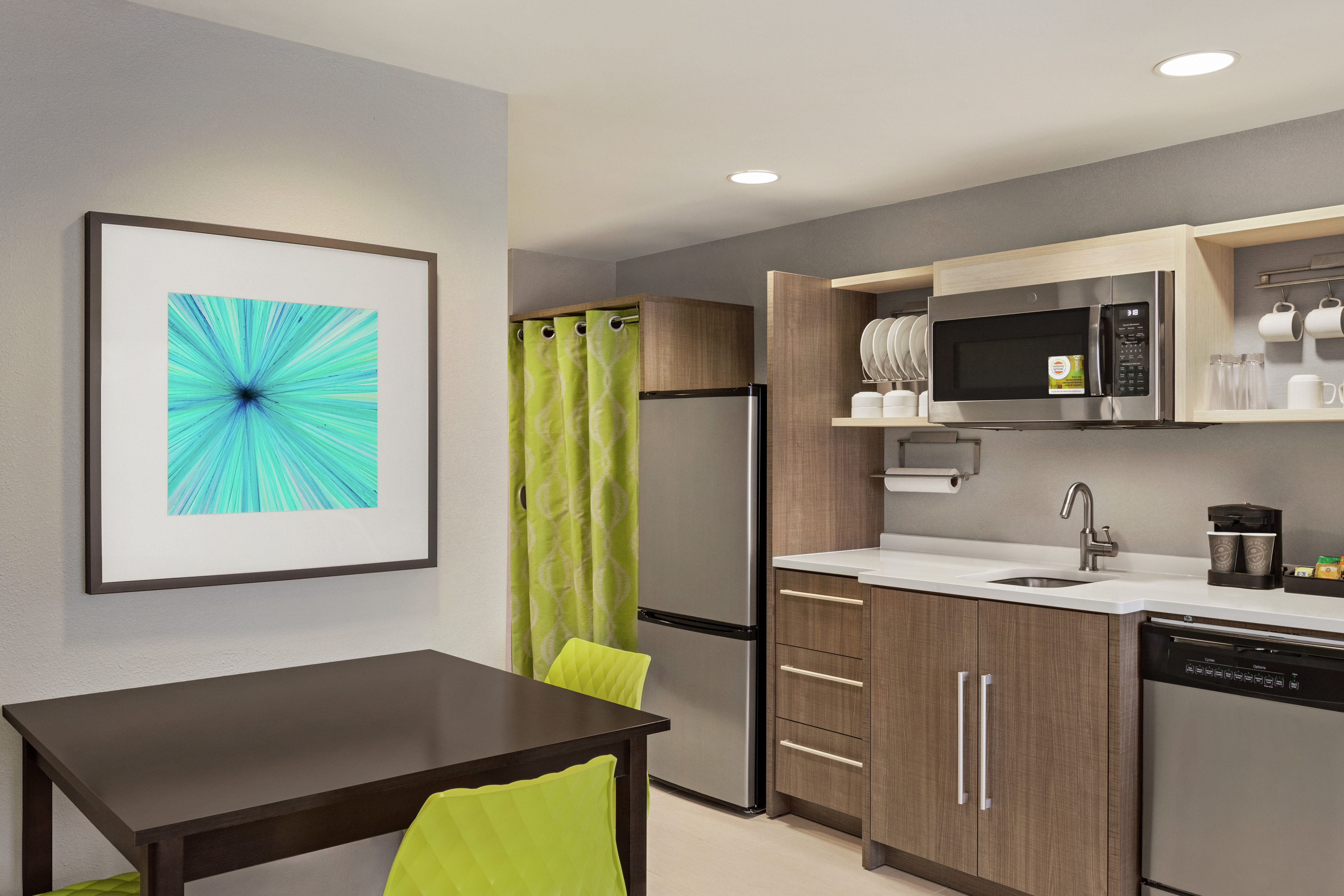 Spacious kitchen in suite featuring eat-in dining table, dishwasher, fridge, microwave, and dishwasher.