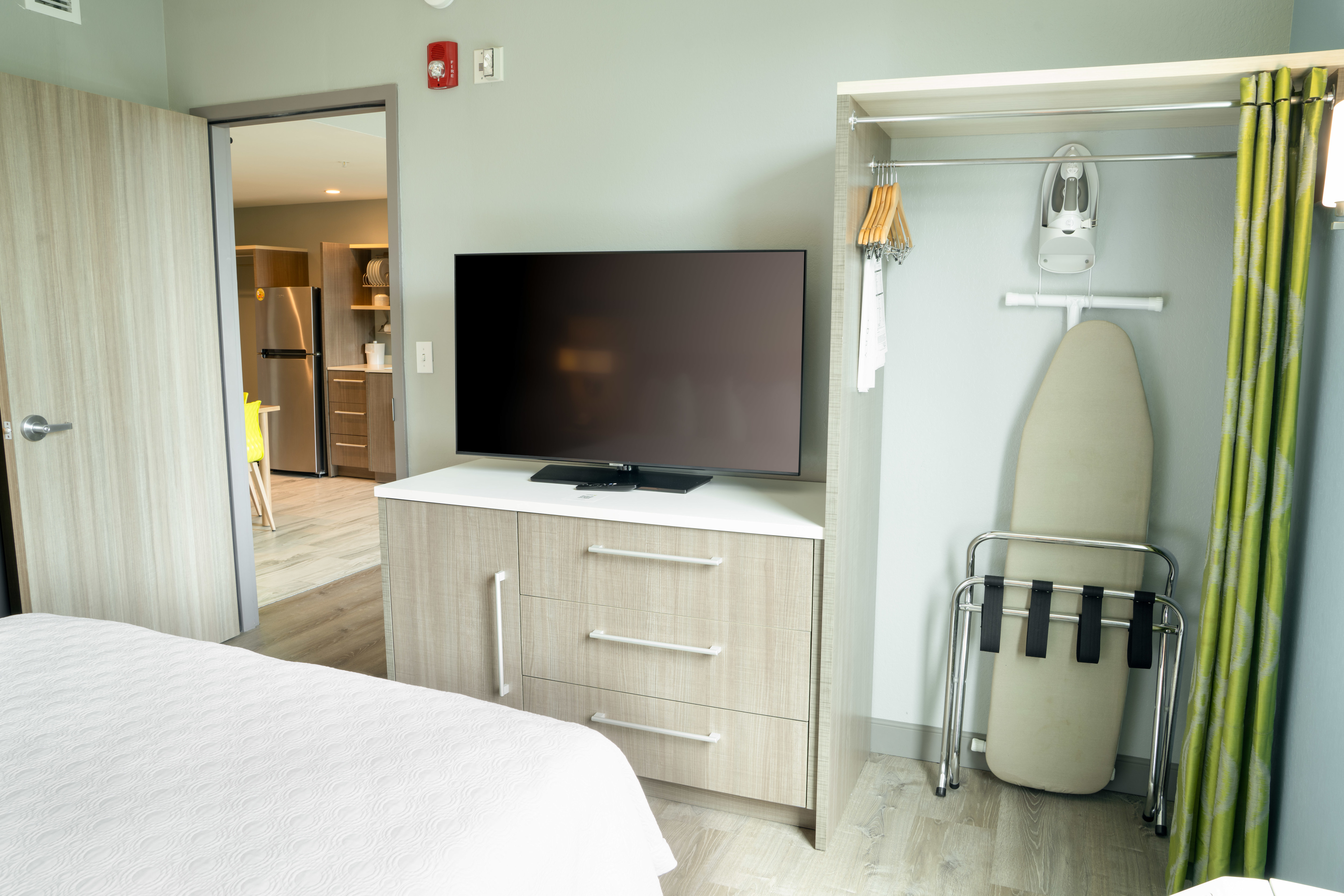 Guest Room with a Comfortable Bed and Ironing Board