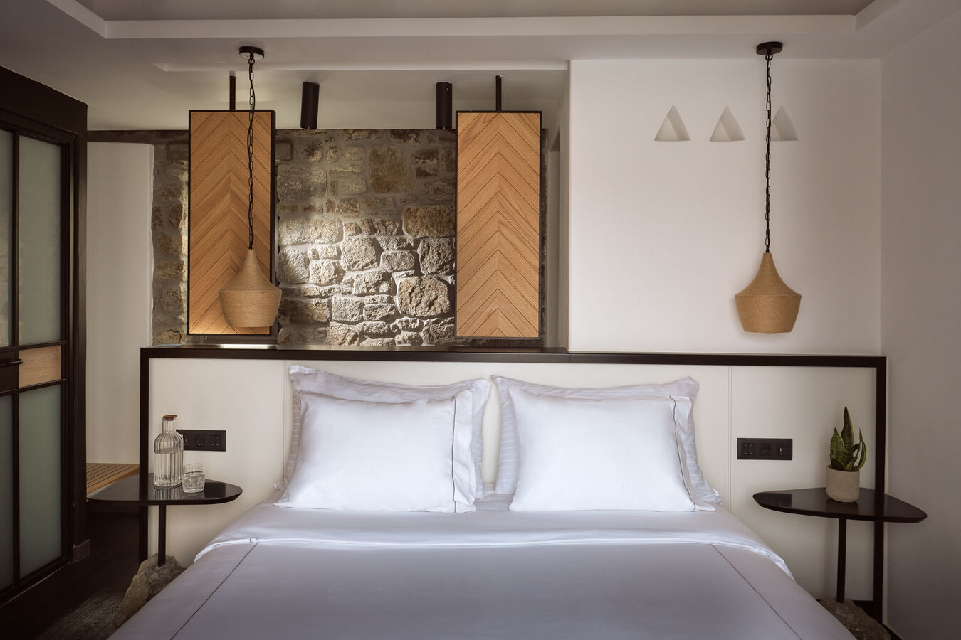 Bed in room with tables and plants