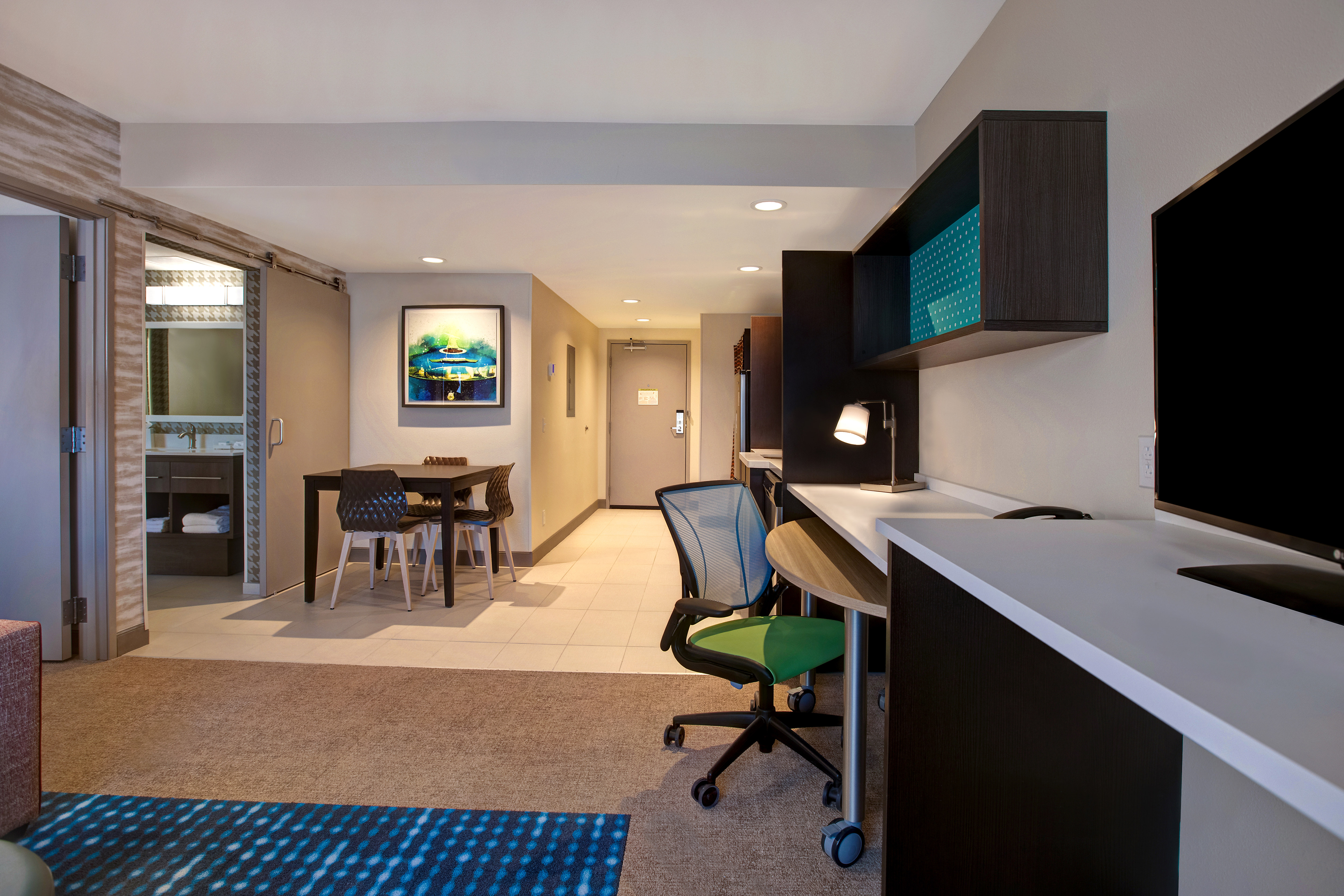 guest room with television work desk dining table and entry