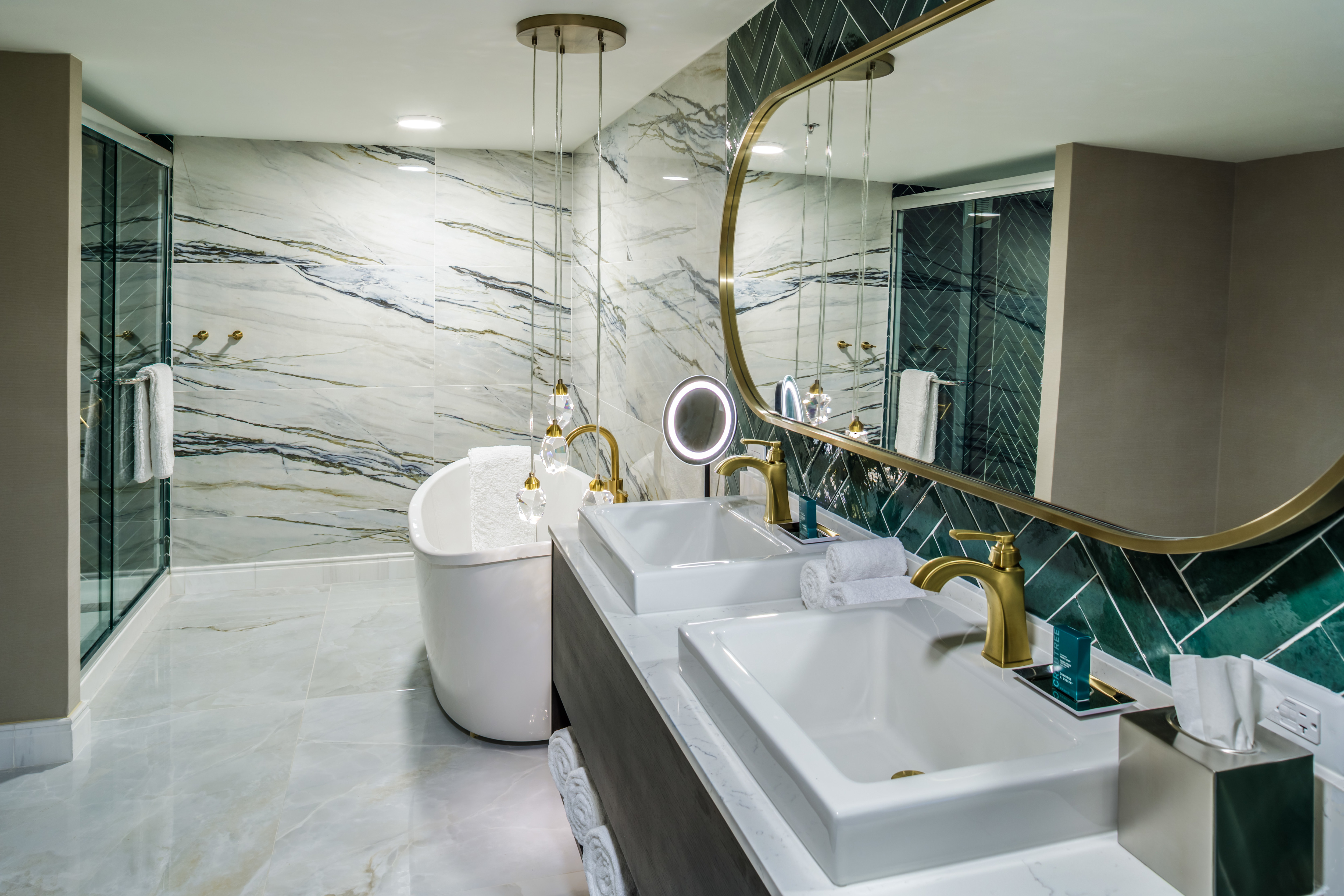 Presidential suite bathroom with a double sink vanity, a standalone tub, and a walk-in shower.