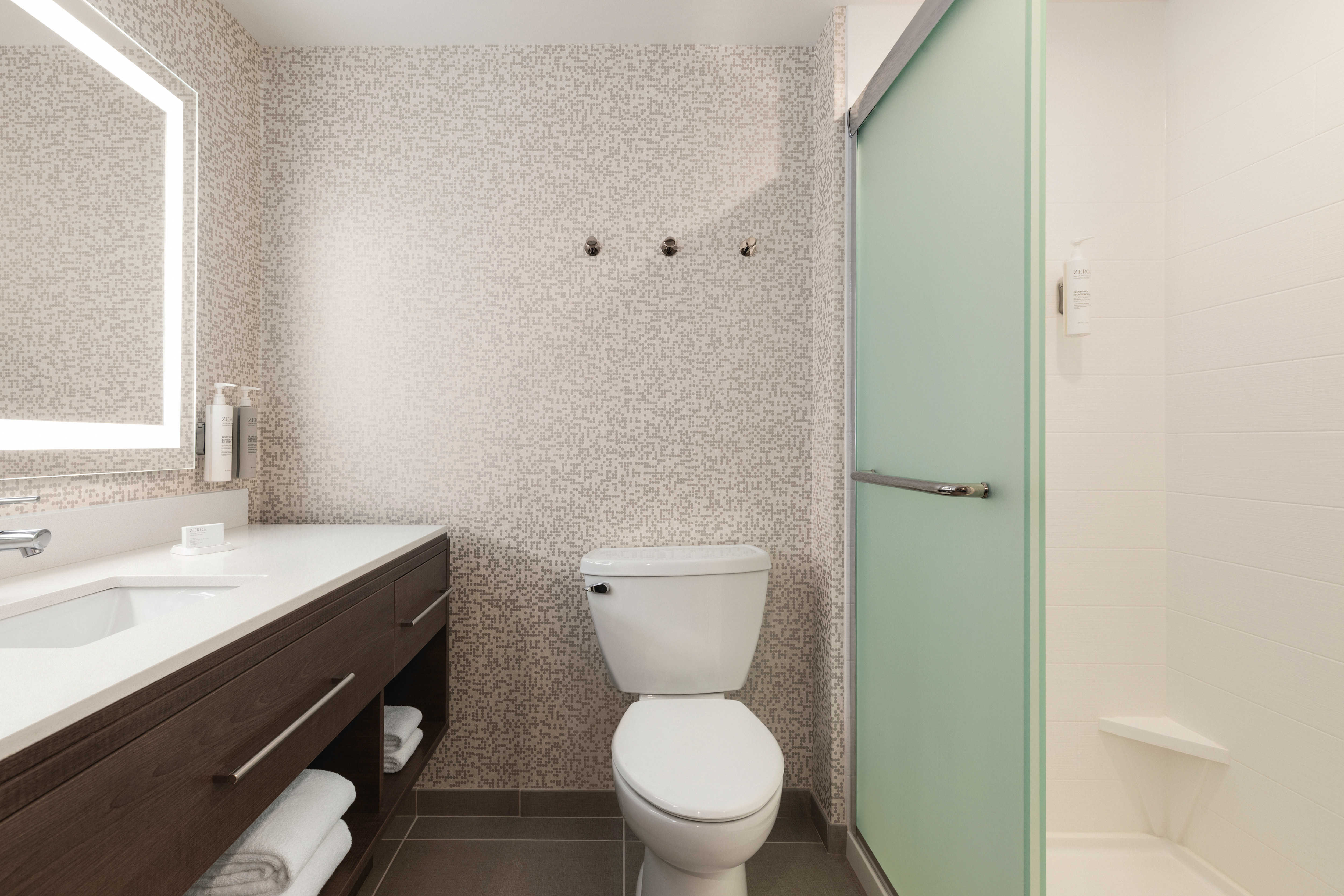 Guest room bathroom with a glass shower and large vanity
