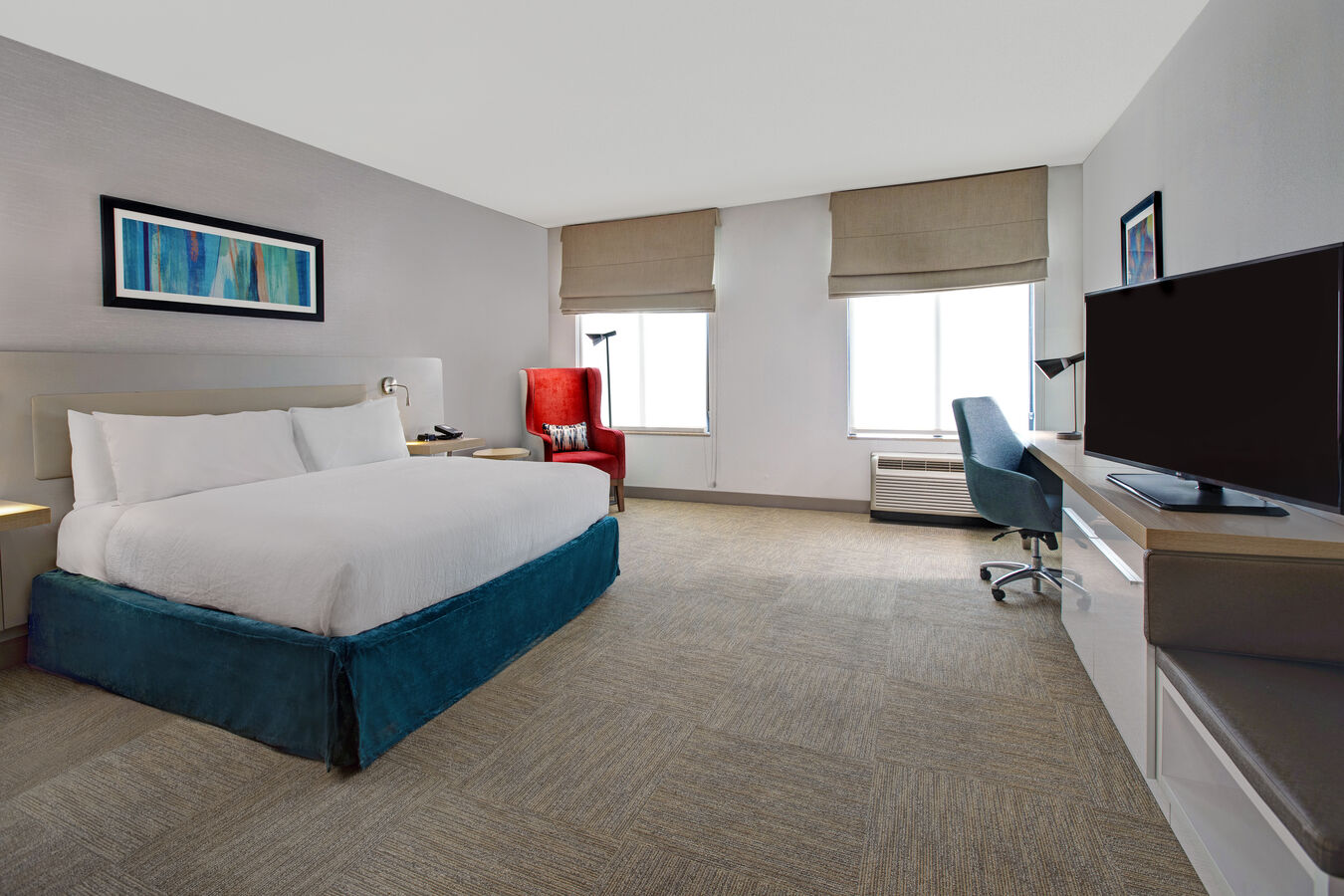 guest room with bed window television work desk and lounge chair