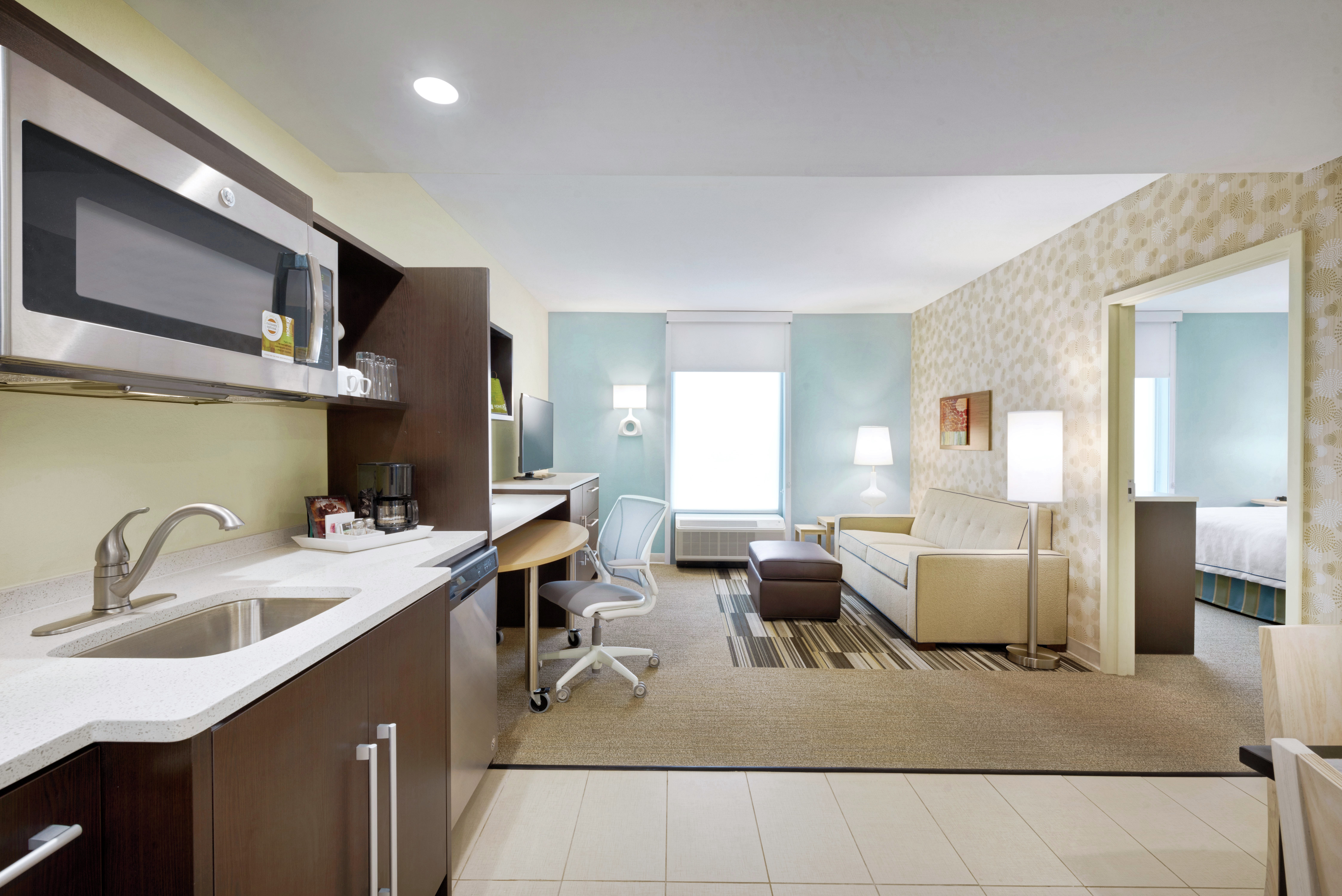 One Bedroom Suite Kitchen and Living Area with Doorway Open to Bedroom