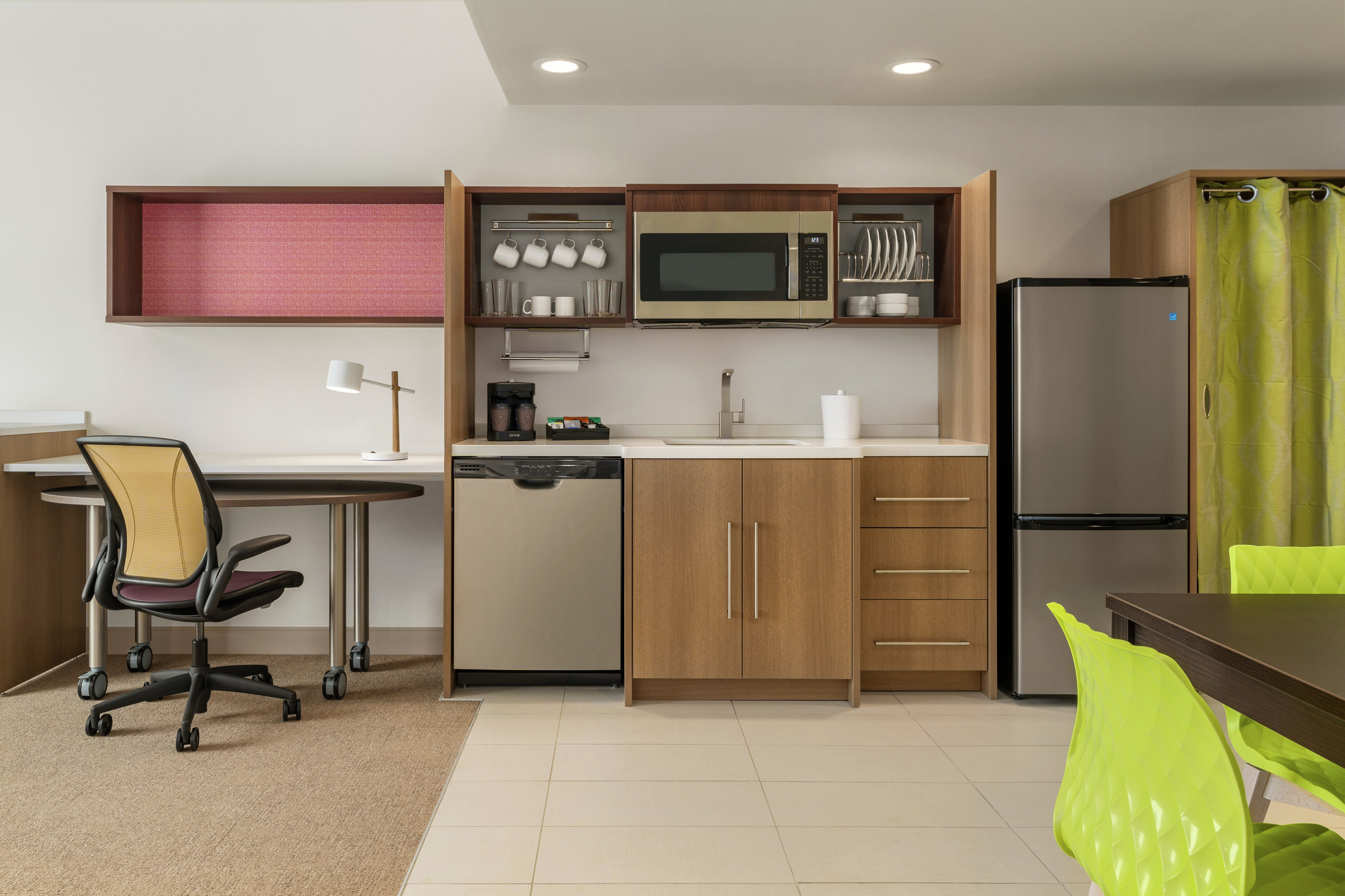 Spacious living area in suite featuring fully equipped kitchen, dining table, and work desk.