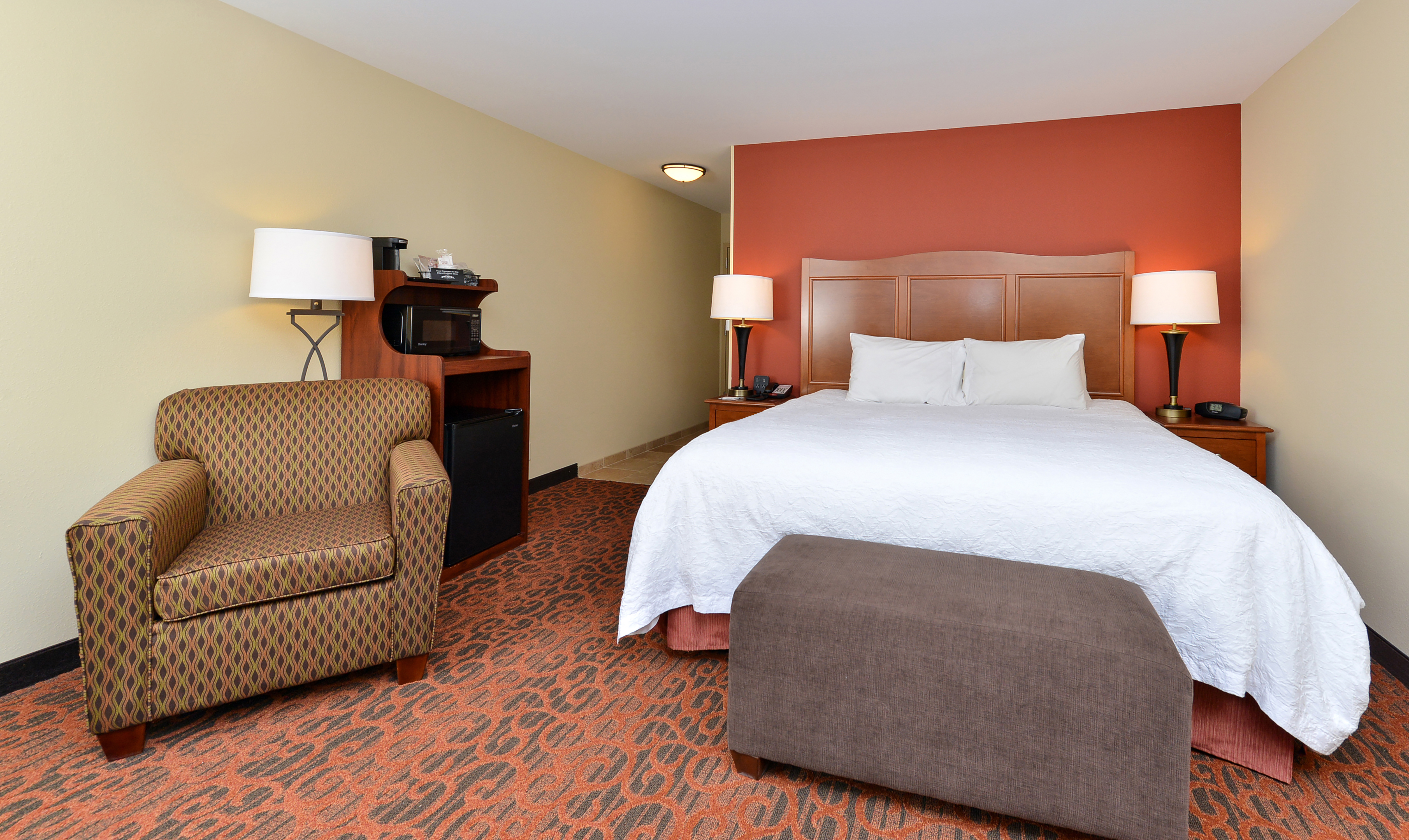 One King Bed Guest Bedroom with Armchair and Beverage Station
