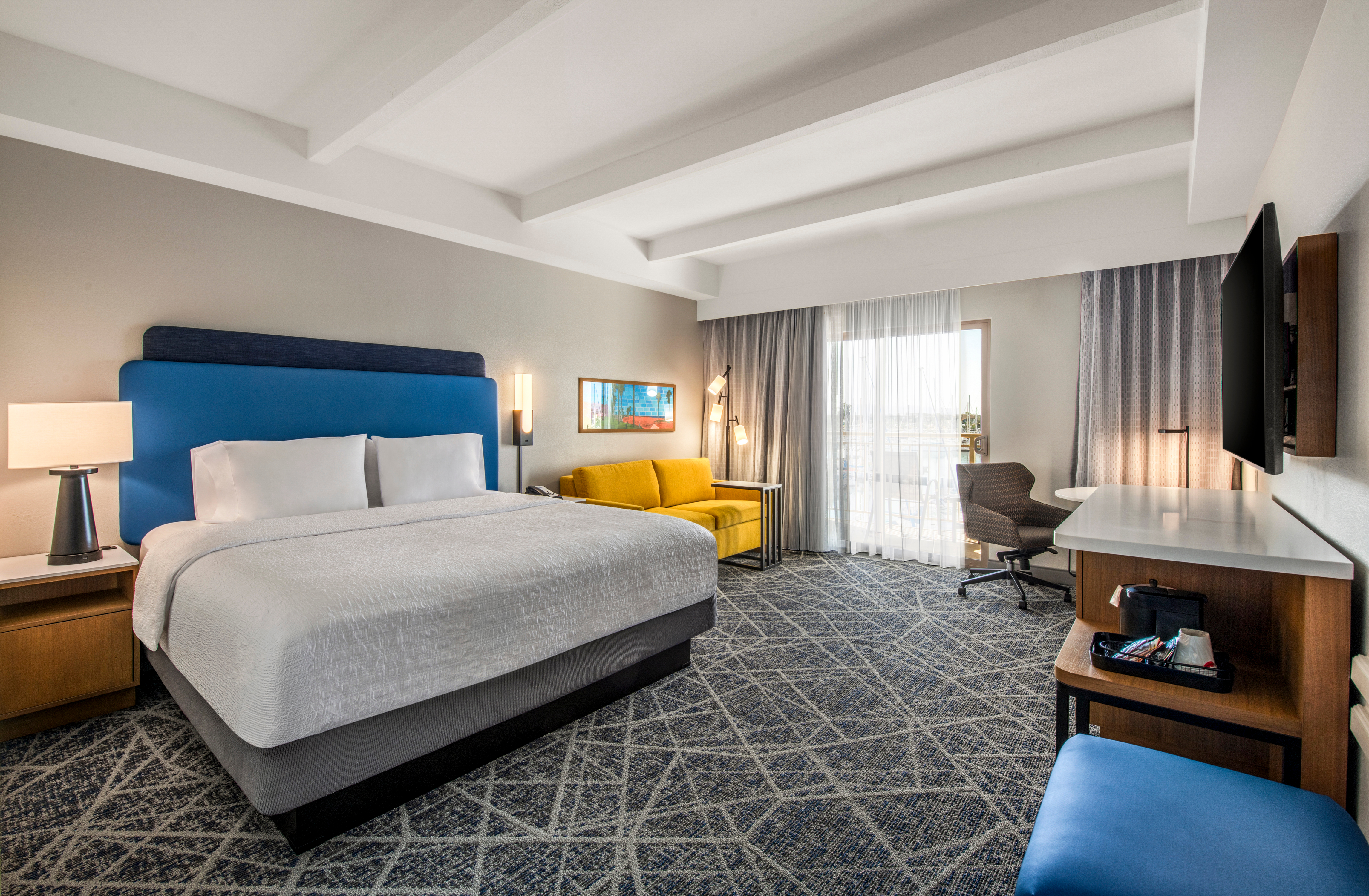 Spacious guest room with king bed and blue headboard