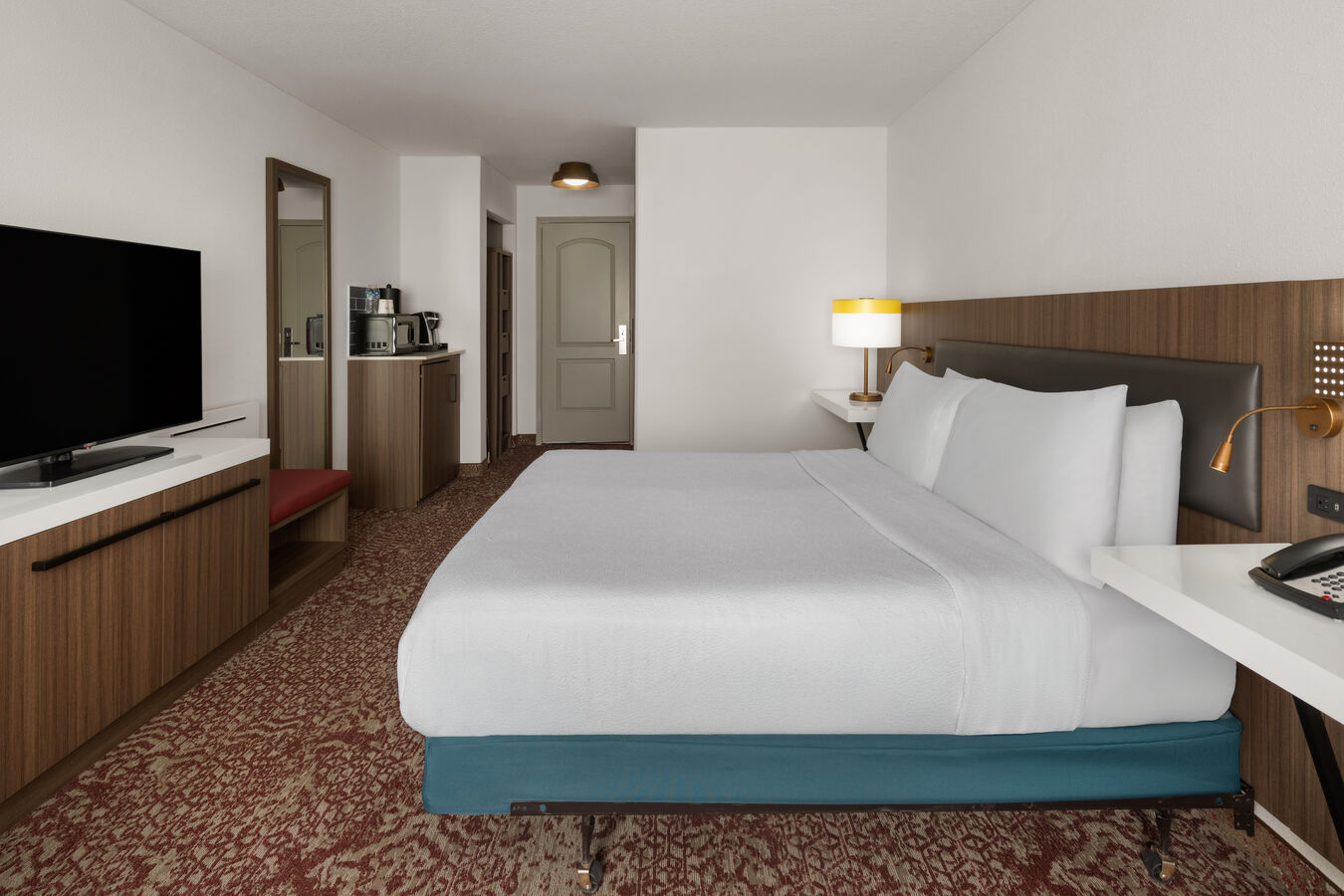 Guest room with a white bed and television