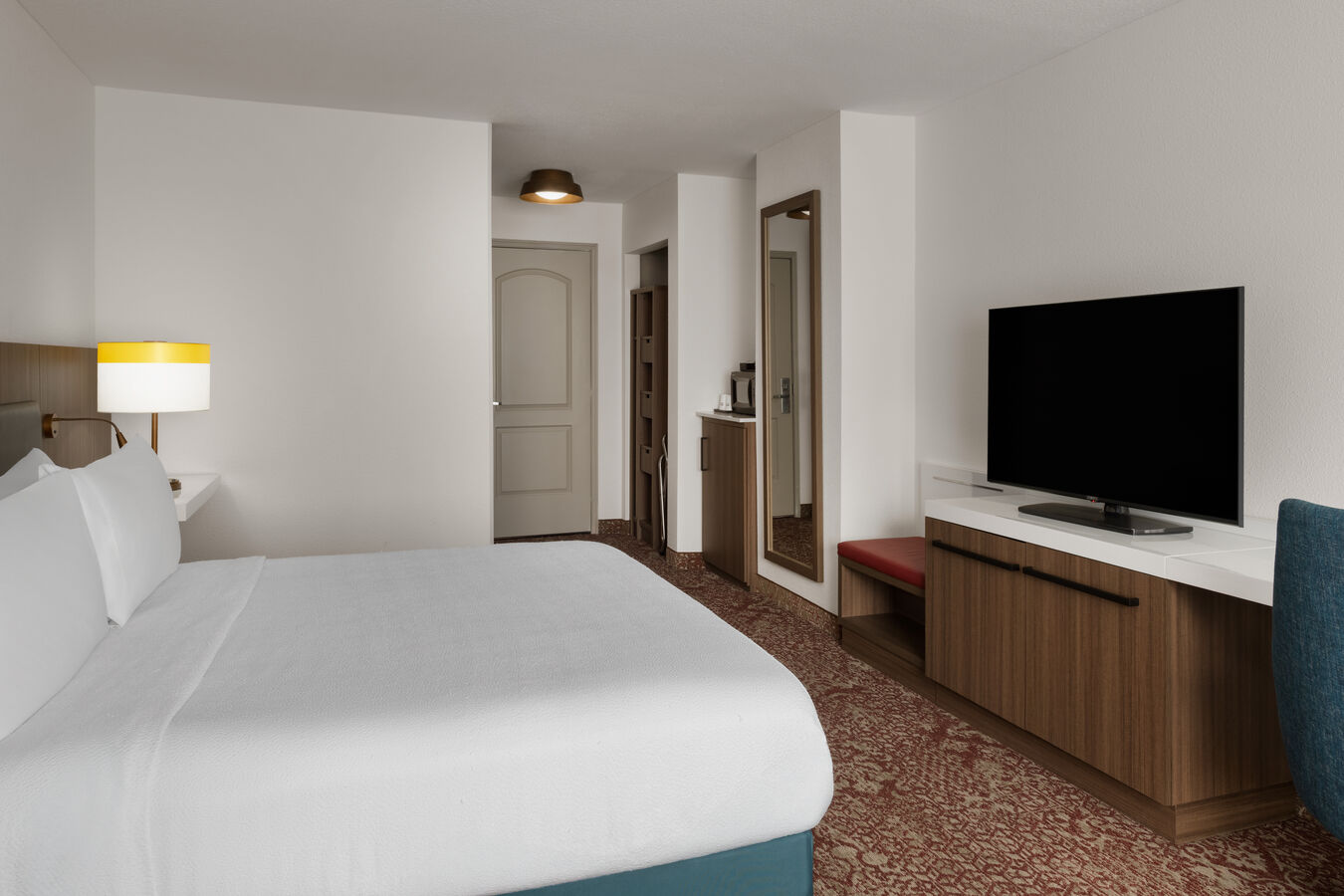 a white king sized bed in front of a television